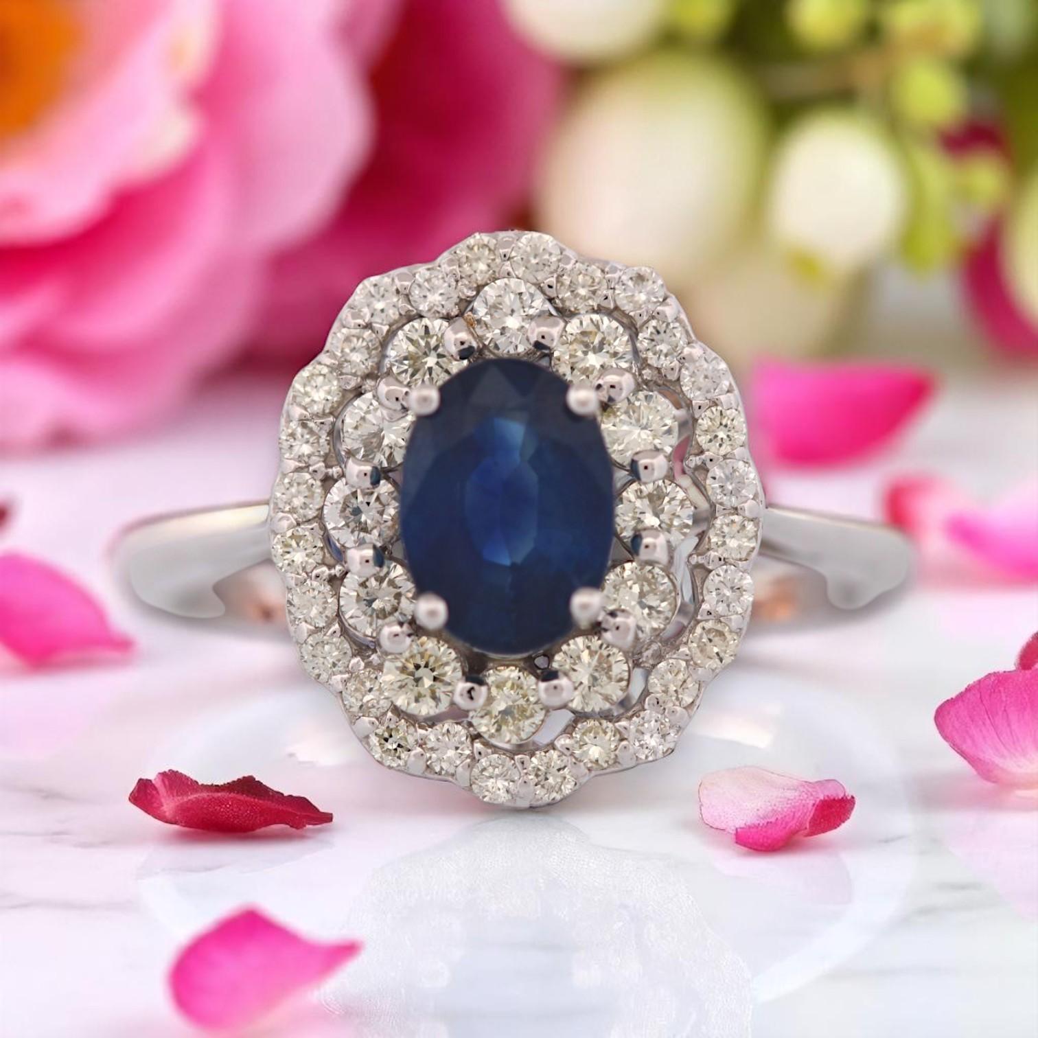 Classic beauty with an irresistible sparkle. The Maude Ring by Mountain Song Jeweler features a stunning 1 carat natural oval sapphire, glowing with deep celestial blue. Framing the centerpiece is a dazzling double halo of .44 carats of natural
