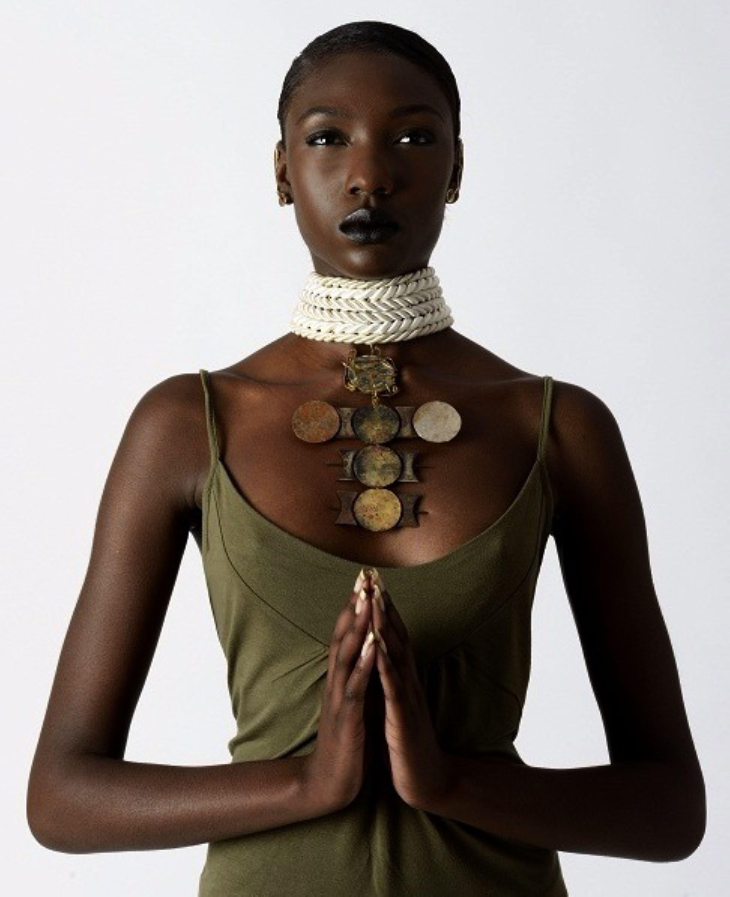 Influenced by the essence of a woman named Dominique, who embodies both saintliness by day and an intriguing persona by night. This unique piece features a cross pendant with wire wrapping details and adorned with satin robes. It exudes captivating