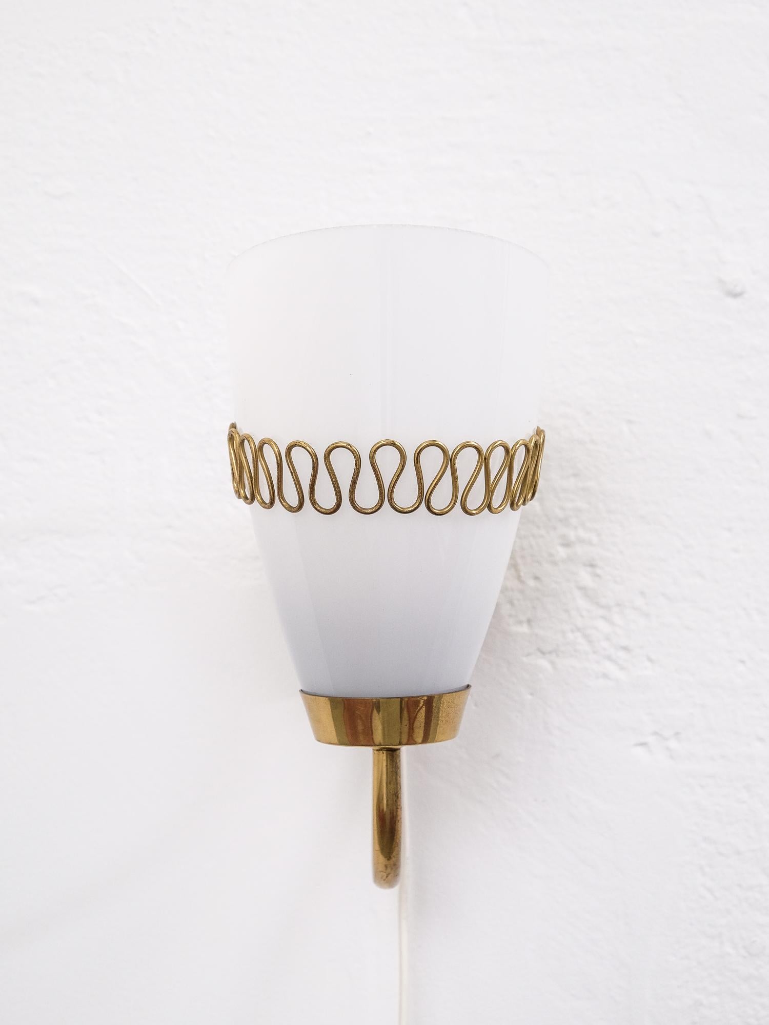 An elegant brass and glass sconce by Mauri Almari for Idman, model 71048, circa 1950s. E27 bulb holder.