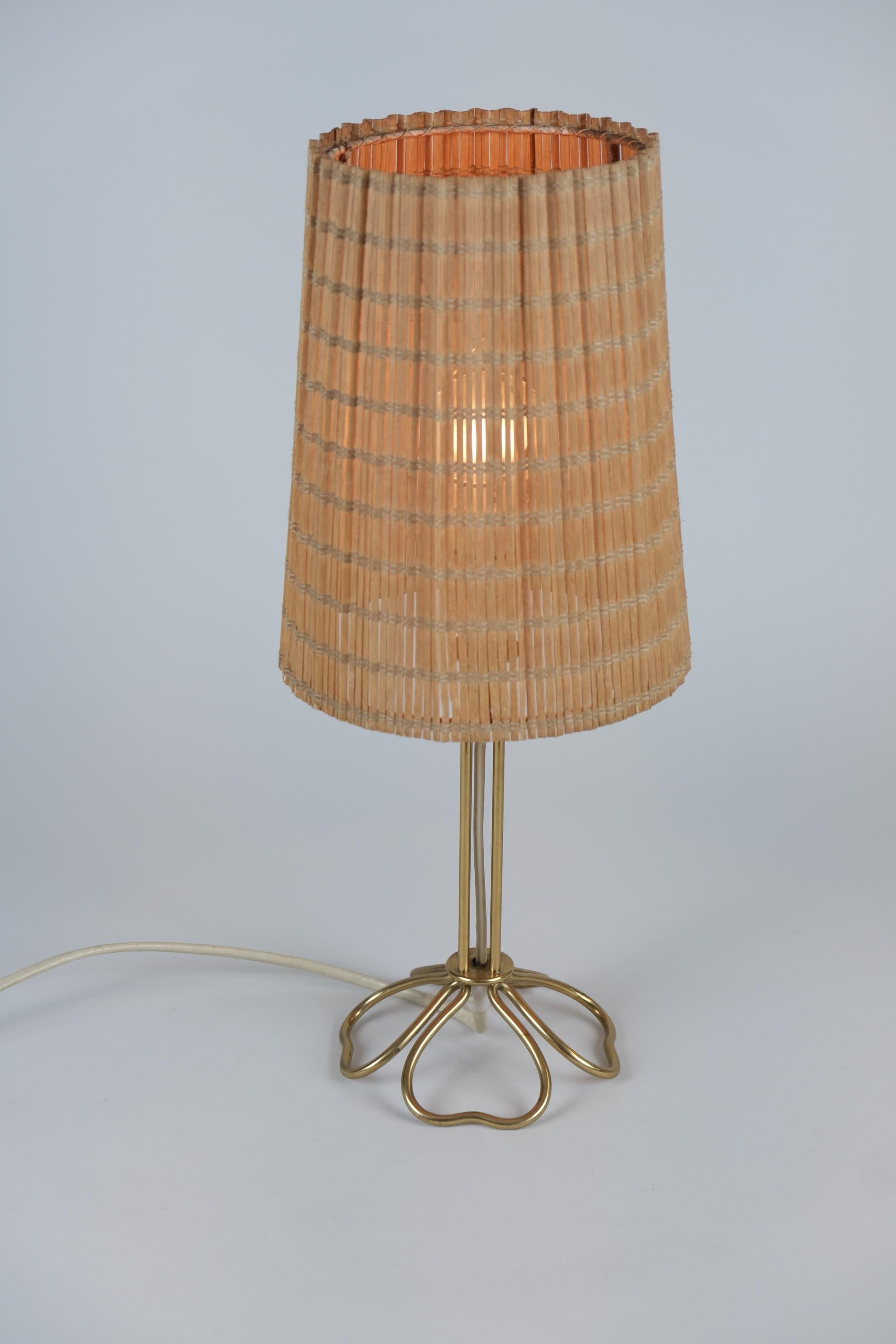 Une belle et délicate lampe de table en laiton conçue par Mauri Almari et fabriquée par Idman dans les années 1950 en Finlande. Malgré la petite taille de cette lampe, la combinaison du laiton et de l'abat-jour en bois crée une image chaleureuse