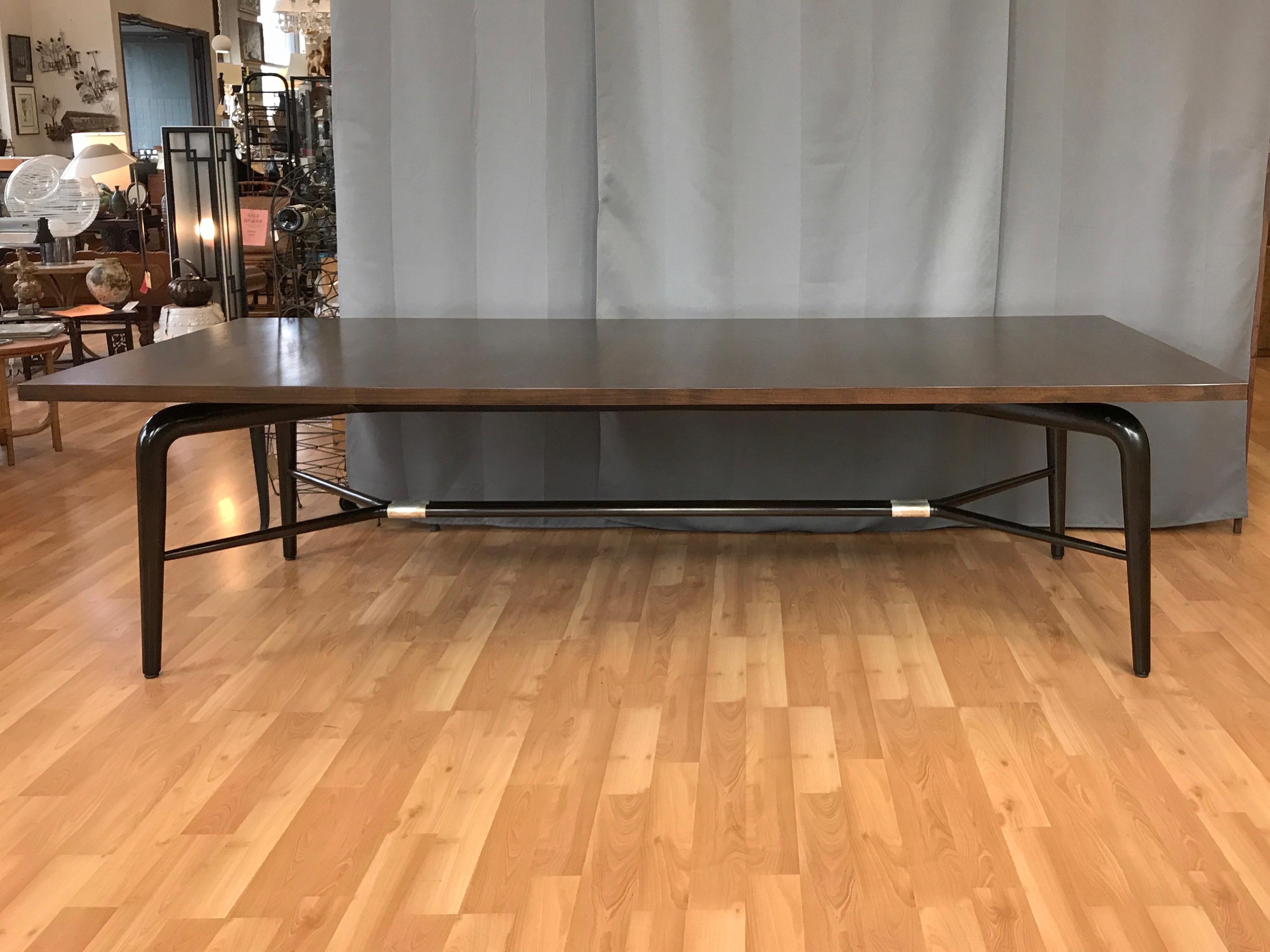 An uncommonly monumental midcentury walnut dining or conference table by Maurice Bailey for Monteverdi-Young of Beverley Hills, California.

Exceptionally handsome and expansive statement piece has a freshly refinished espresso brown satin top,