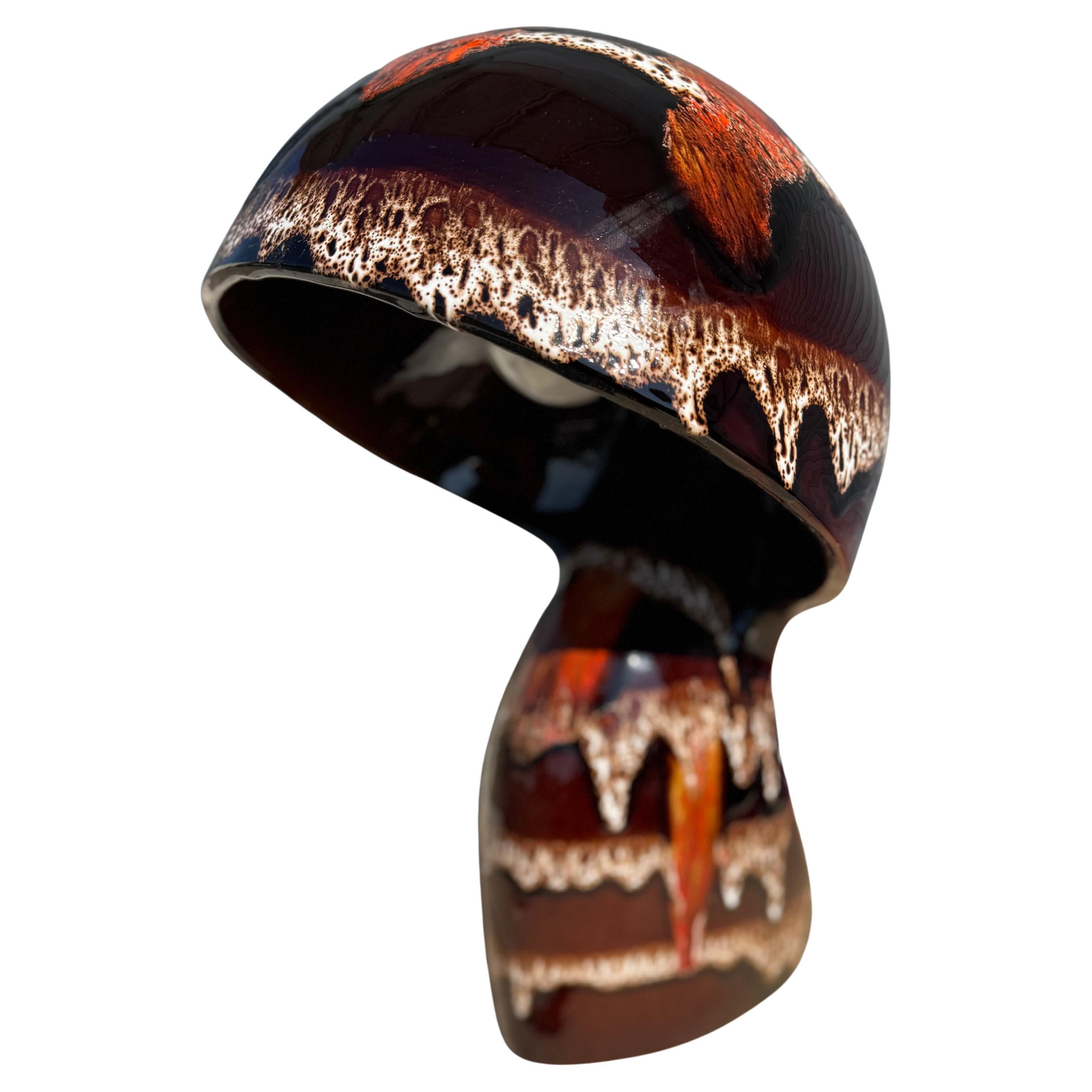 Il s'agit d'une rare lampe Maurice Chalvignac en forme de champignon émaillé Lava.
La lampe est moulée en une seule pièce. L'abat-jour et la base de la lampe ne font qu'un.
L'interrupteur se trouve sur le dessus du champignon.
Ce glaçage est un