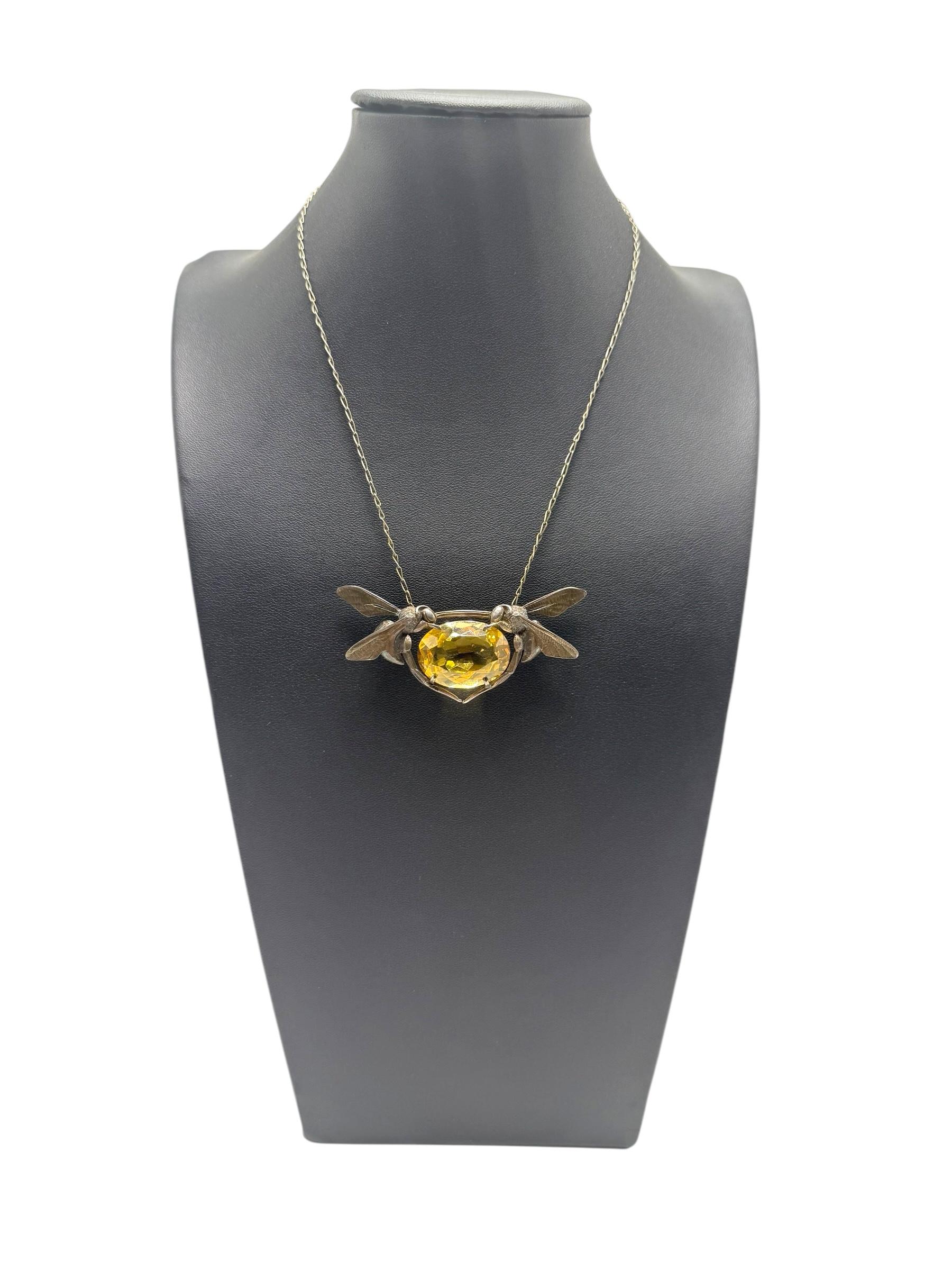 Collana in argento sterling disegnata dal gioielliere francese Maurice Daurat, attivo durante il periodo dell'Art Nouveau. Questo pezzo presenta due insetti scultorei, probabilmente libellule, che affiancano simmetricamente un grande citrino dal