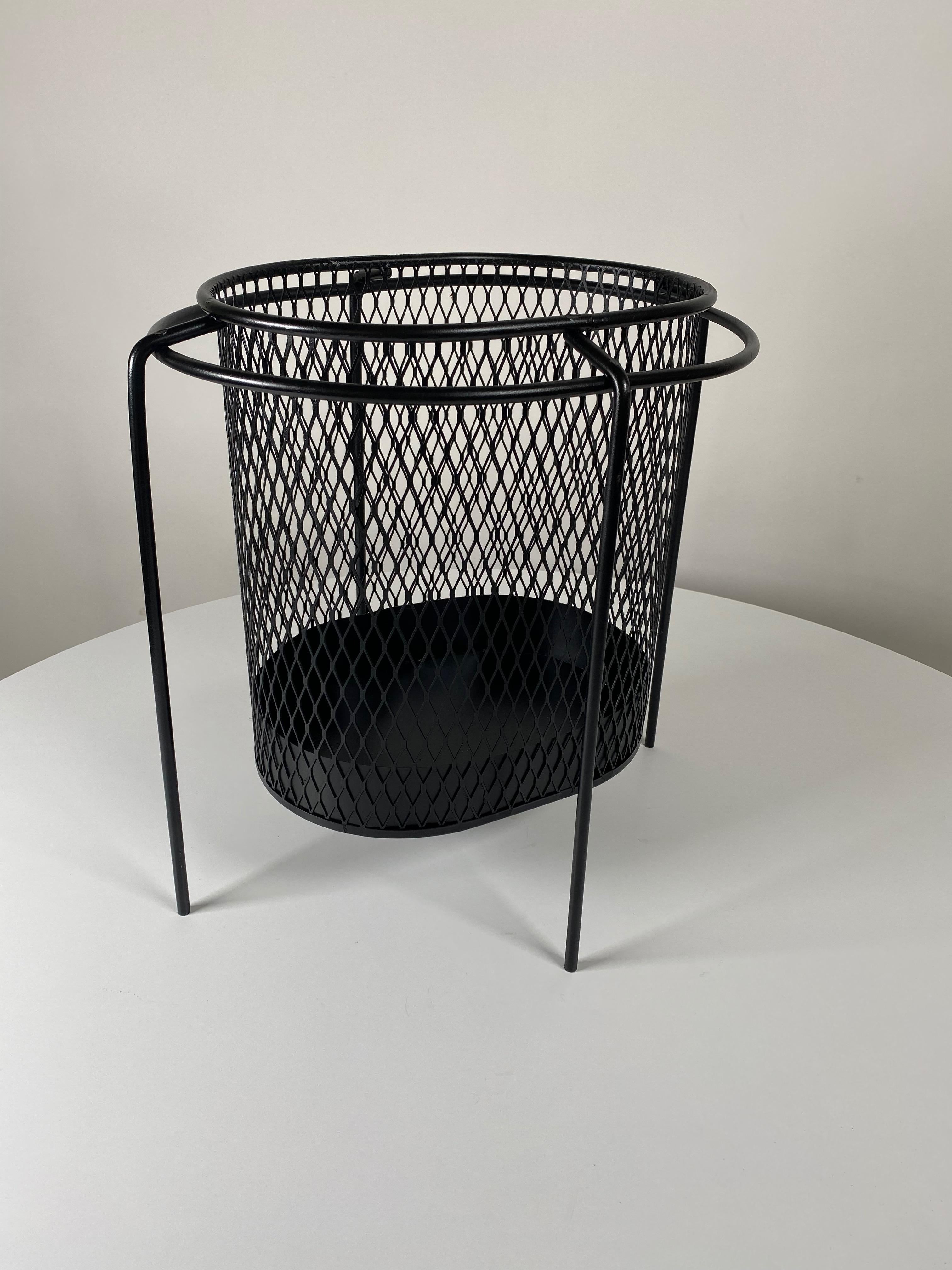 Expanded metal wastepaper basket by Industrial Designer Maurice Duchin in black, the basket is suspended by an oval ring attached to four bent metal legs. The Modernist take on the wastepaper basket as a design statement from the 1950s. Free