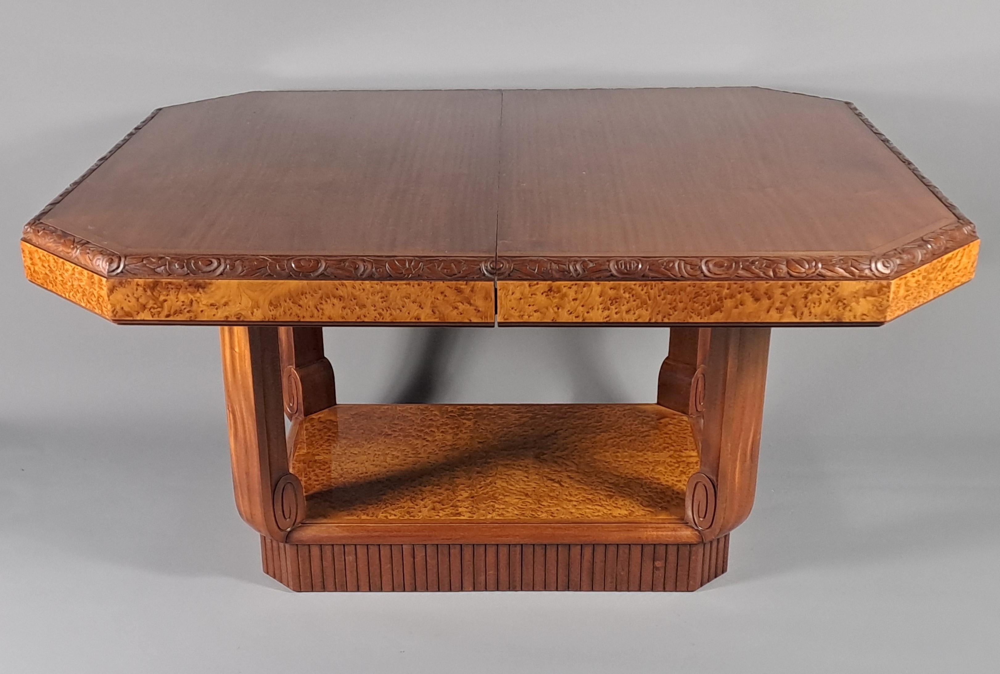Maurice Dufrène (1876-1955)

Belle table de salle à manger en acajou massif et placage de ronce d'amboine avec un plateau octogonal bordé d'une frise sculptée de motifs végétaux stylisés.
Quatre pieds massifs à terminaison en volute sur la partie