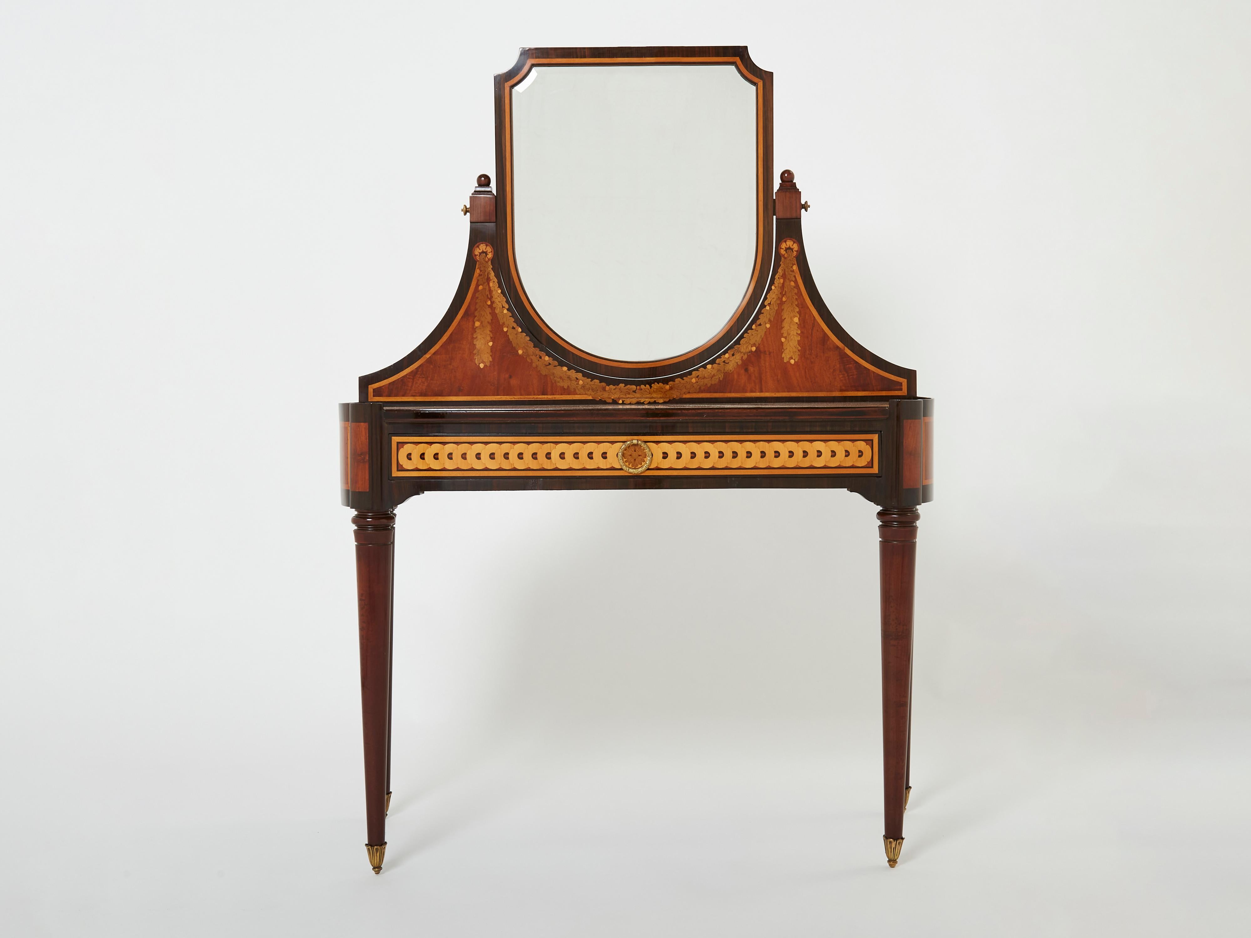 This French early Art Deco vanity is attributed to Maurice Dufrene for La Maitrise, Les Galeries Lafayette arts décoratifs ateliers in Paris launched in 1922. This dressing table is completely veneered in various woods including amaranth, rosewood