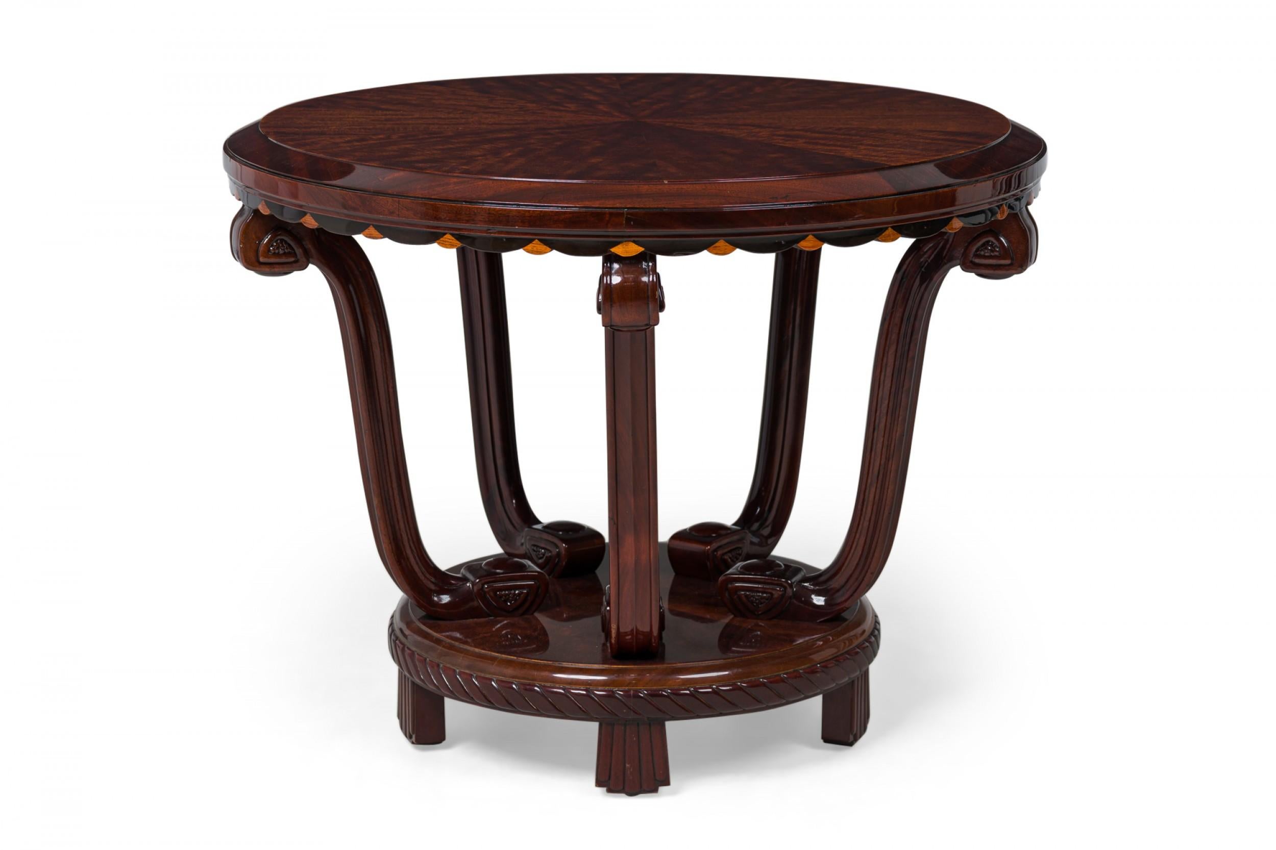 French Late Art Deco palisander circular center / side table with a veneered top and base in radial formation, scalloped apron with inlaid wedges, 5 carved legs mounted to the base which features a central inlaid circle and molded rope frieze,