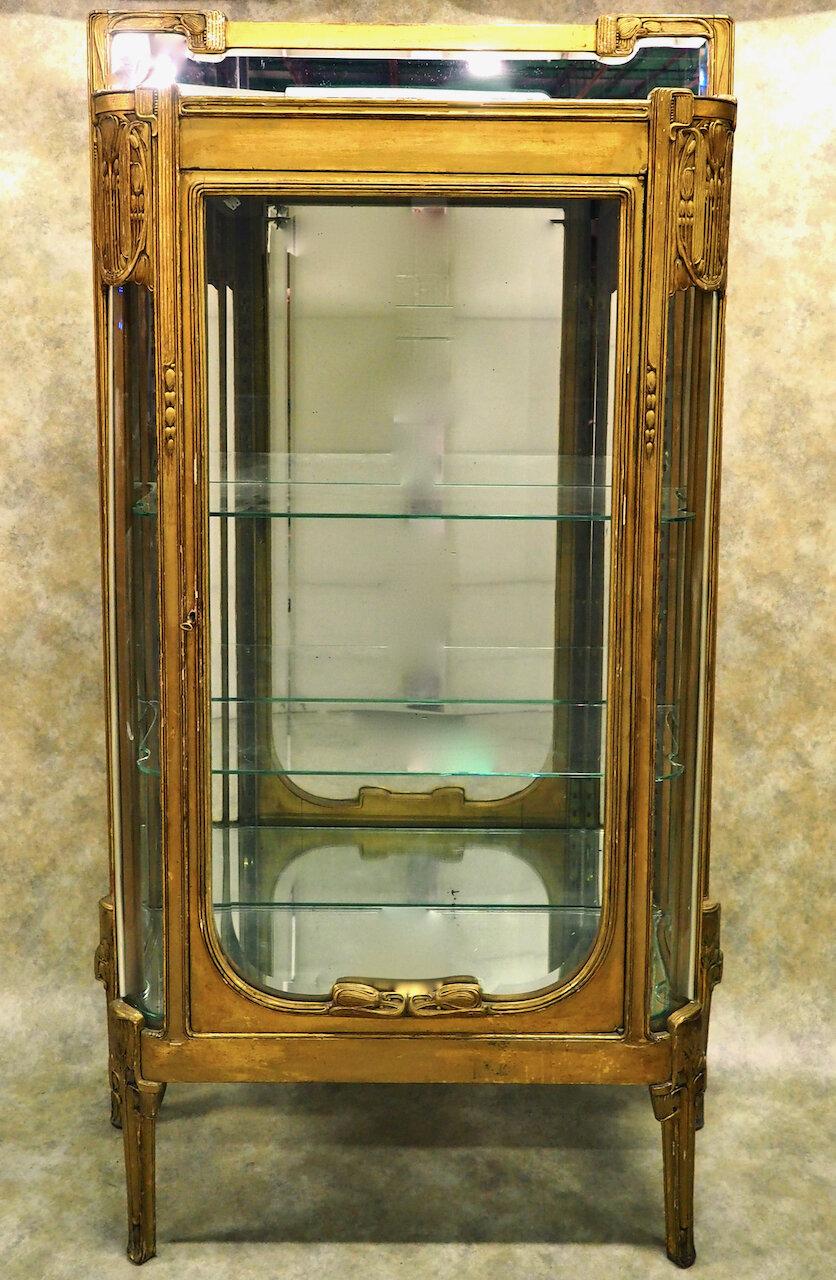 Armoire/vitrine Art Déco classique précoce de Maurice Dufrene, vers 1912, en bois sculpté et doré. Ce meuble est représenté dans l'Hôtel Parrticulier de Dufrène, au 22, rue Bayard à Paris, pris en 1918 (voir photo ci-dessous). La version en bois de