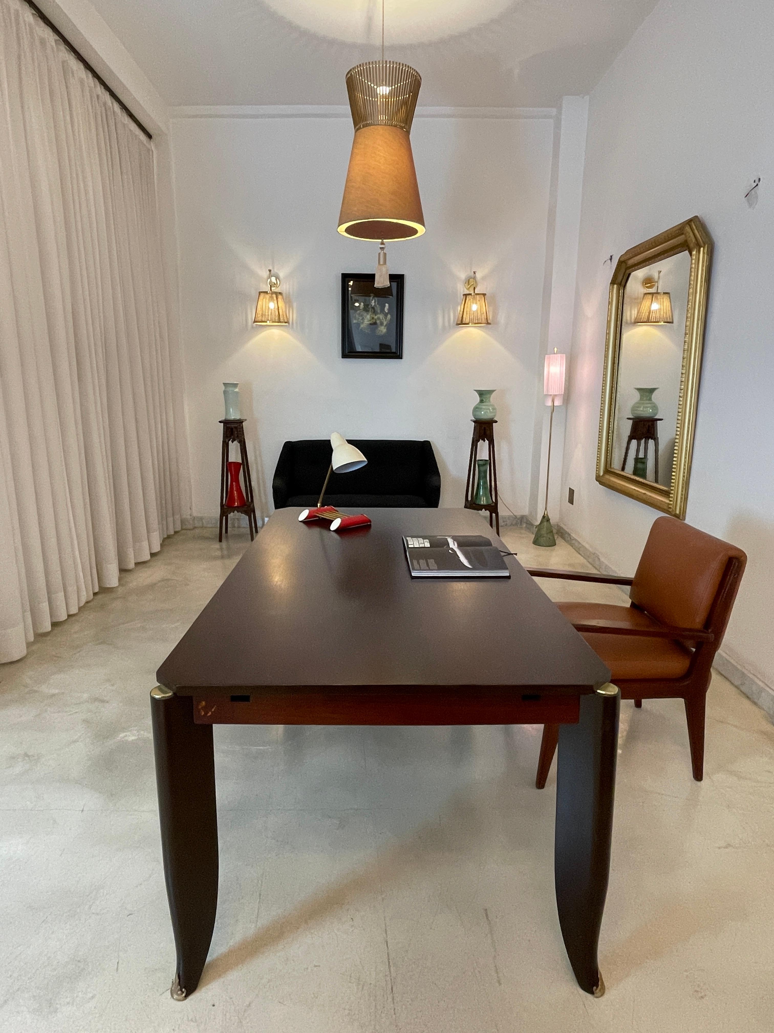 Esta llamativa mesa Art Déco de los años 30, obra del célebre diseñador francés Maurice Jallot, ejemplifica la elegancia arquitectónica y la maestría artesanal de la época. 

El gran tablero descansa sobre cuatro espectaculares patas en forma de