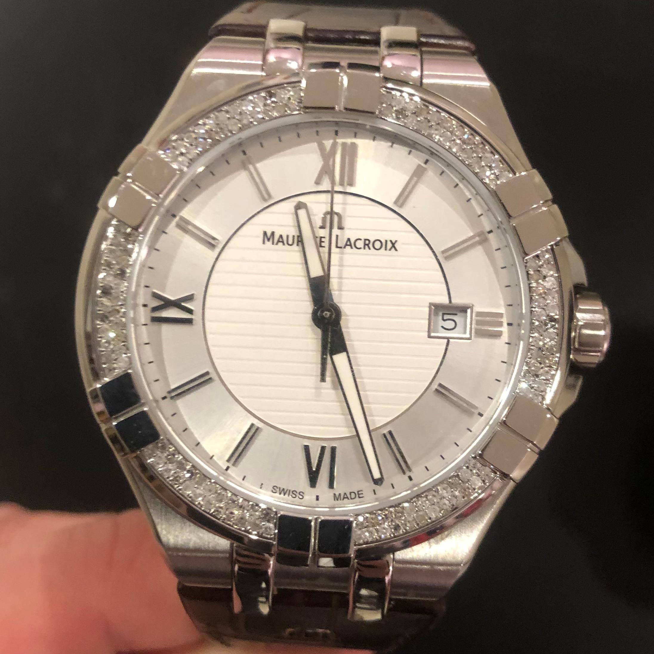 Maurice Lacroix Aikon 42mm Weißes Zifferblatt mit Diamantbesetzter Lünette.

Dieser Zeitmesser von Maurice Lacroix verfügt über ein Lederarmband mit einer doppelten Faltschließe. Das einzigartige Uhrengehäuse ist mit ca. 1 Karat Diamanten von