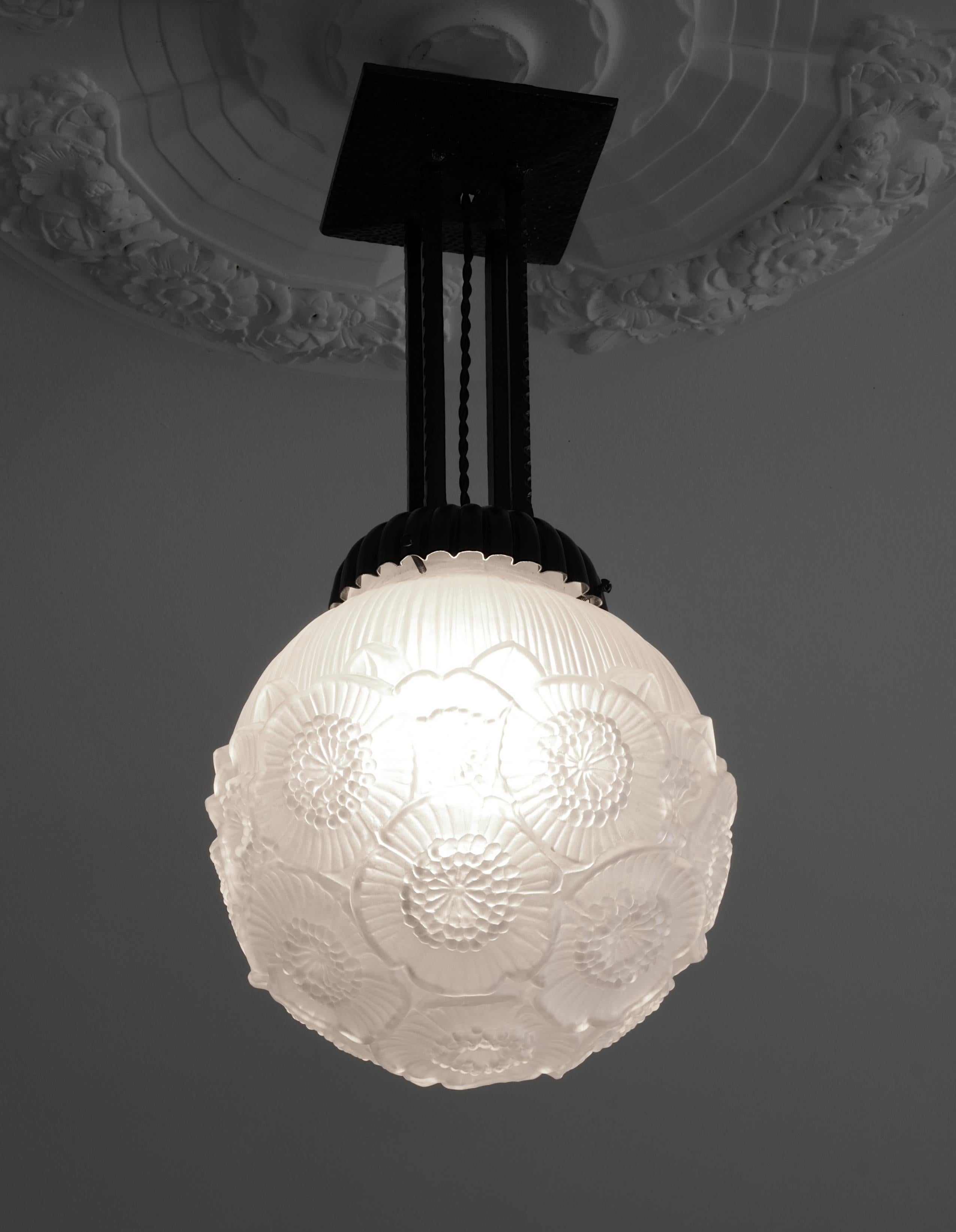 French Art Deco ball pendant chandelier by Maurice Model (Verdun), France, early 1930s. Floral decor. Molded-pressed satiny glass shade. Iron fixture. Height: 20