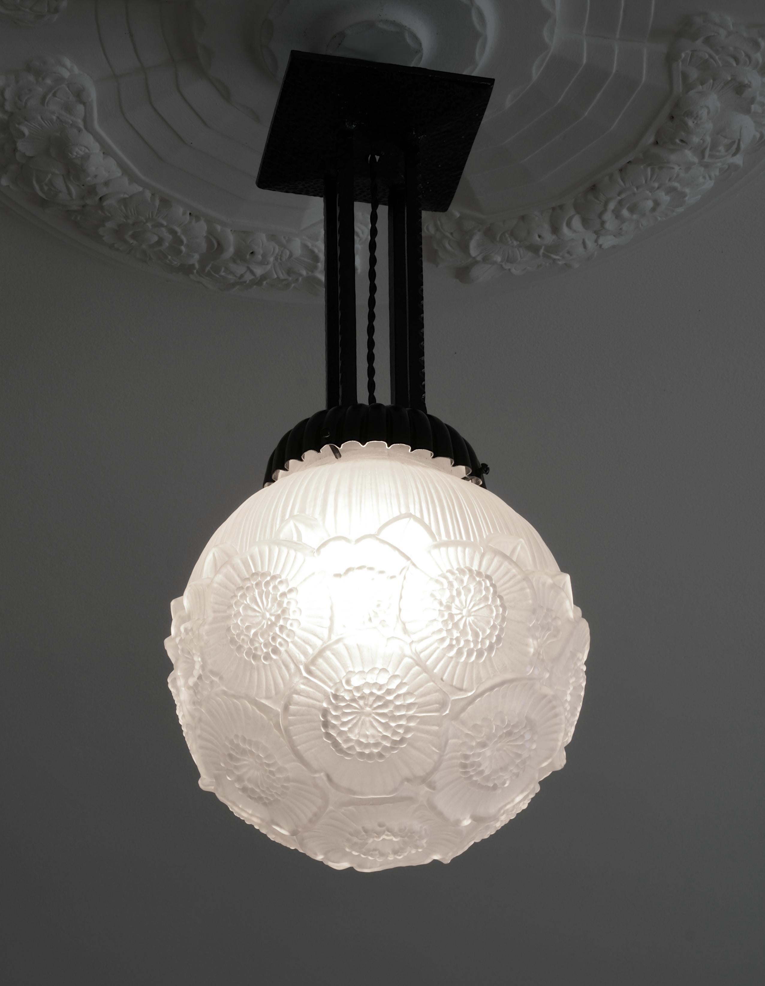 French Art Deco ball pendant chandelier by Maurice Model (Verdun), France, 1920s. Floral decor. Molded-pressed satiny glass shade. Iron fixture. Height: 20