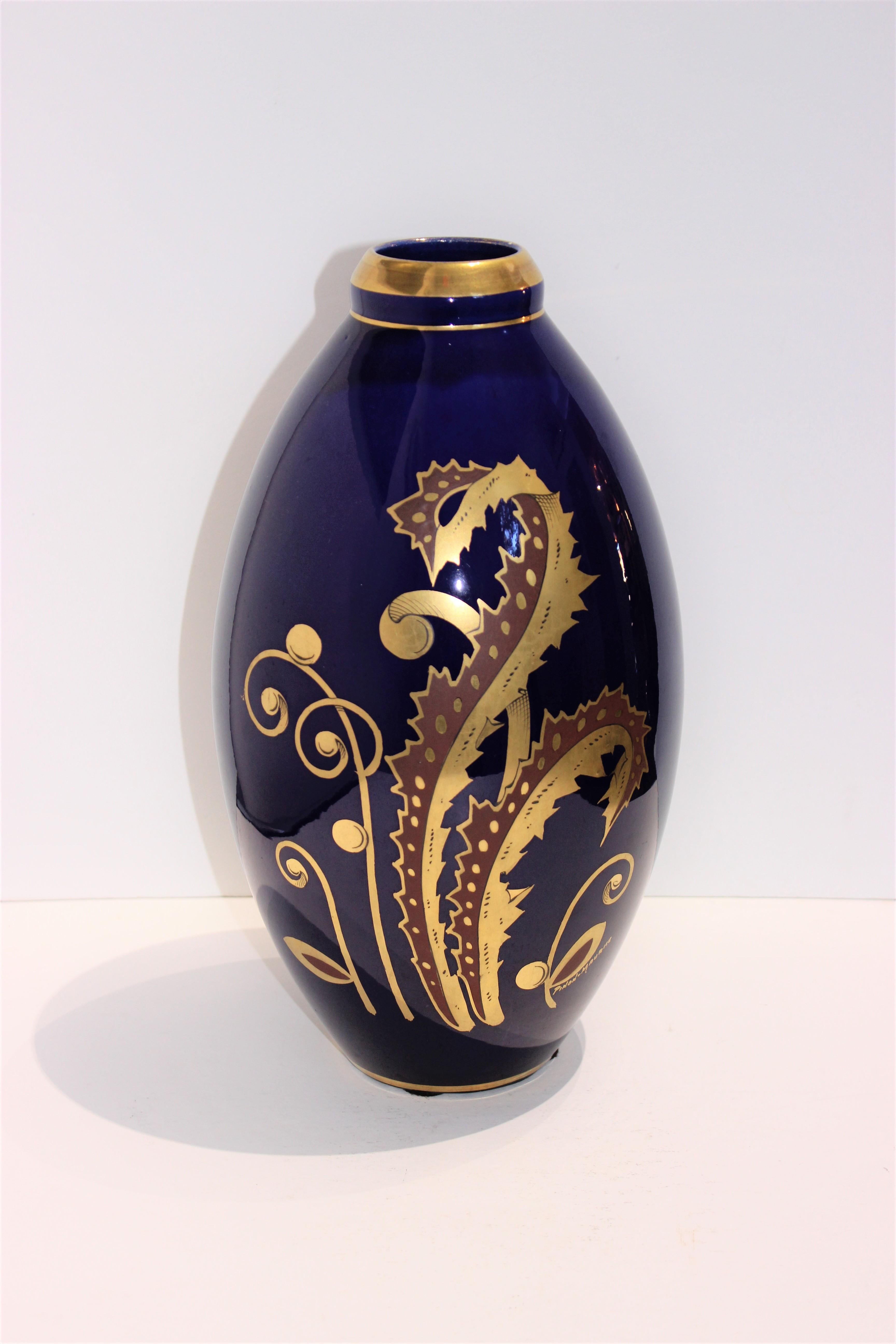 This stylish and chic French Art Deco porcelain vase dates to the 1930s and is hand painted with stylized acanthus and foliage in gilt gold on a cobalt blue base.

Note: Signed by the artist Pinon Maurice (on front of vase to the lower