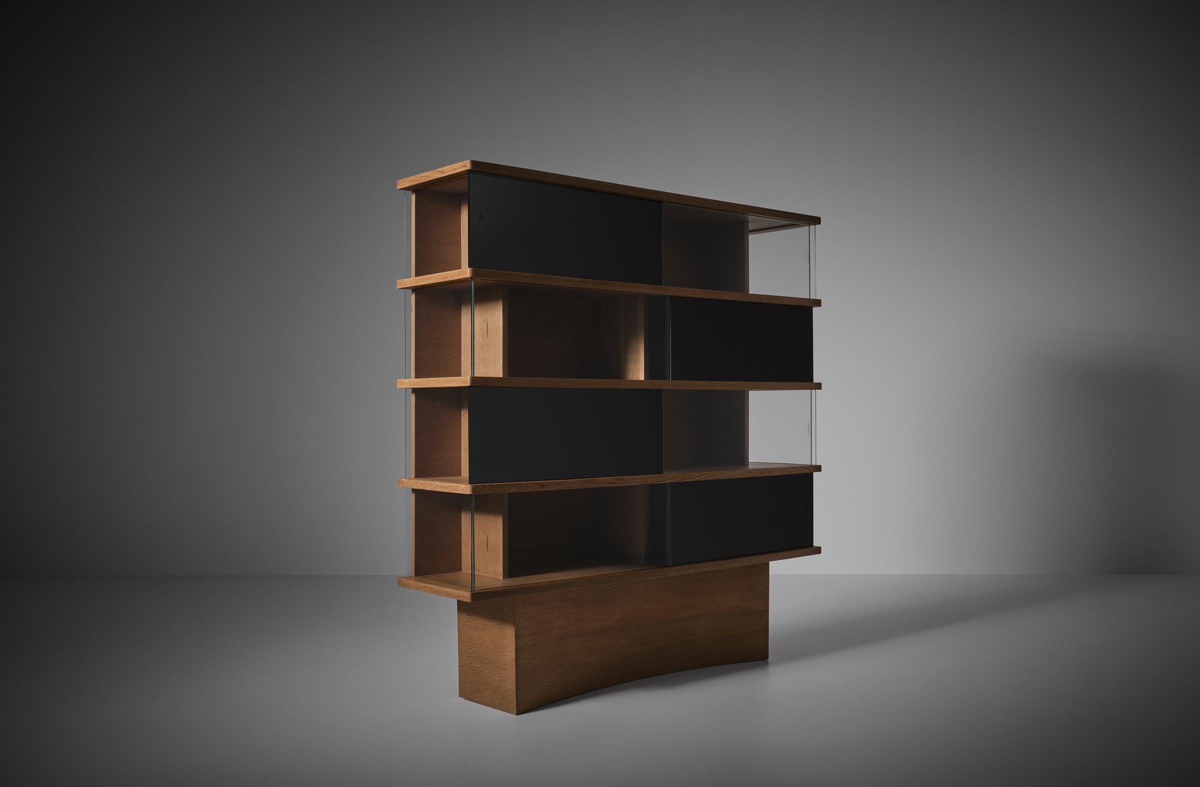 Maurice Pré bookcase edition Emery, France 1954. Wonderful piece with a great architectonical appearance. Very well made Oak wooden structure with a beautiful grain and refined details. The original glass is a combination of black opaline glass and