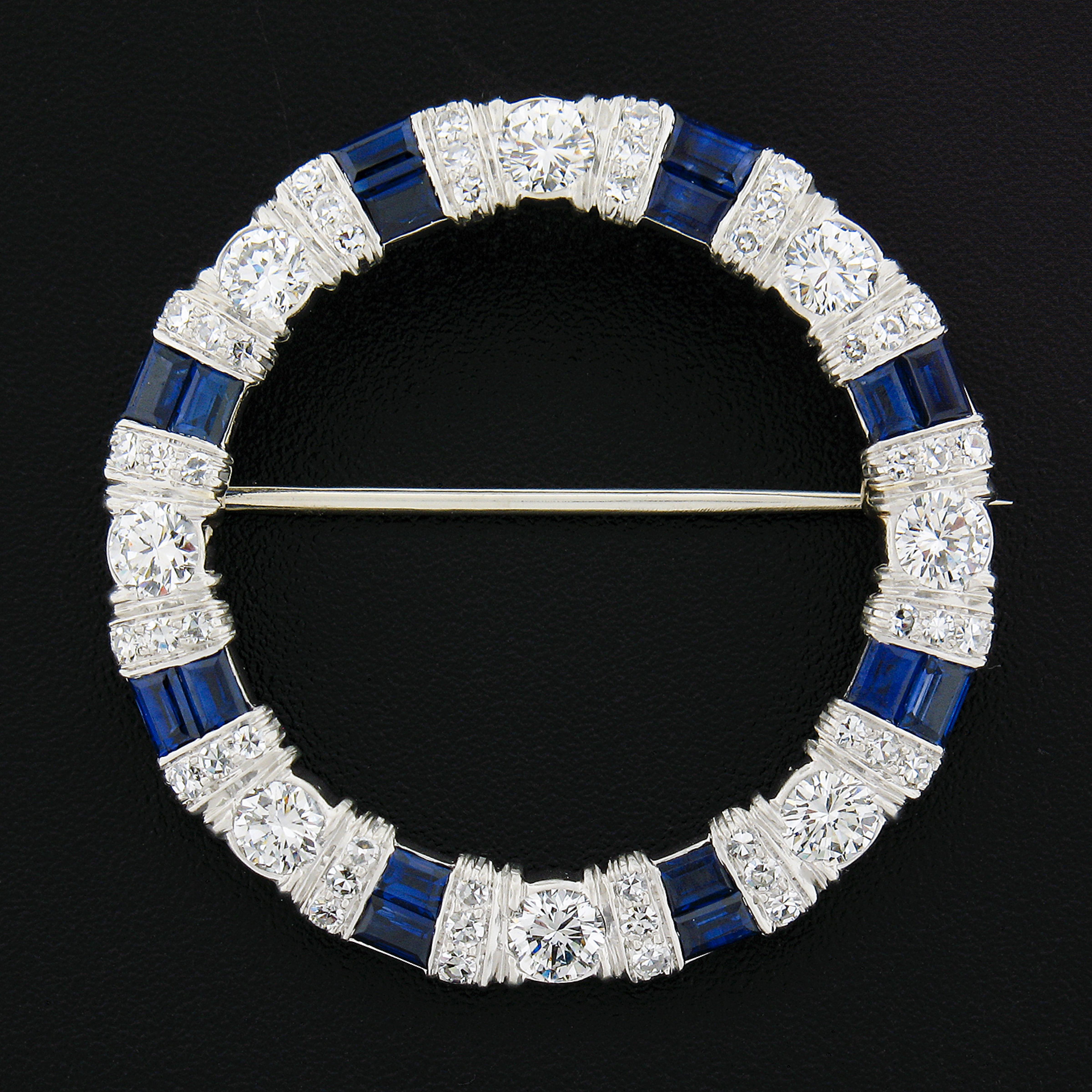 This breathtaking wreath brooch by Maurice Tishman was crafted in solid platinum & 14k white gold pin. The wreath is adorned with old single & transitional cut diamonds that alternate with natural sapphire stones around the design. These sapphires