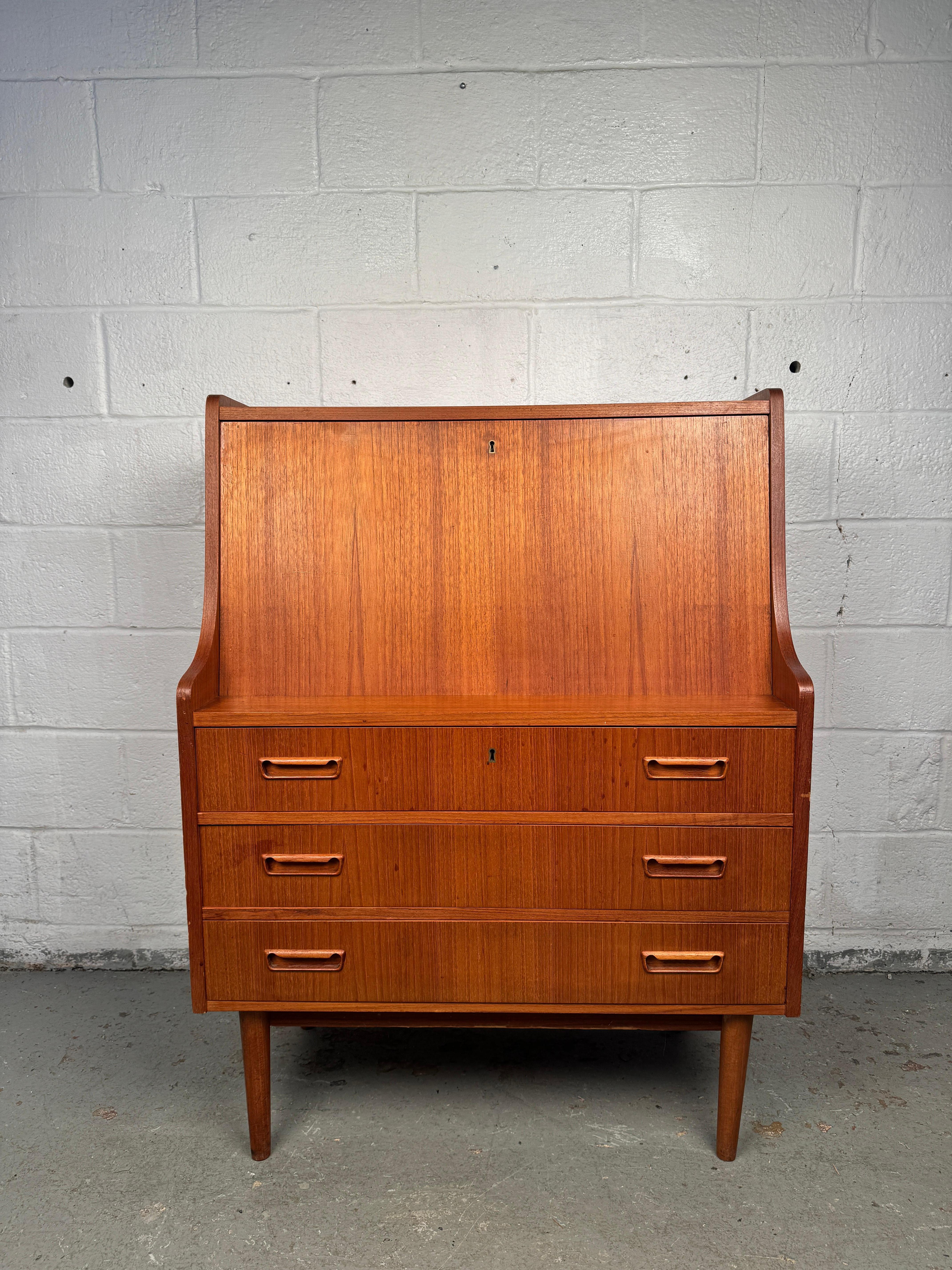 Entdecken Sie die perfekte Verschmelzung von skandinavischem Design und modernem Nutzen mit diesem Maurice Villency Danish Teak Drop-Down Desk. Als raffiniertes Beispiel für die Handwerkskunst der Jahrhundertmitte verbindet dieses Möbelstück klare