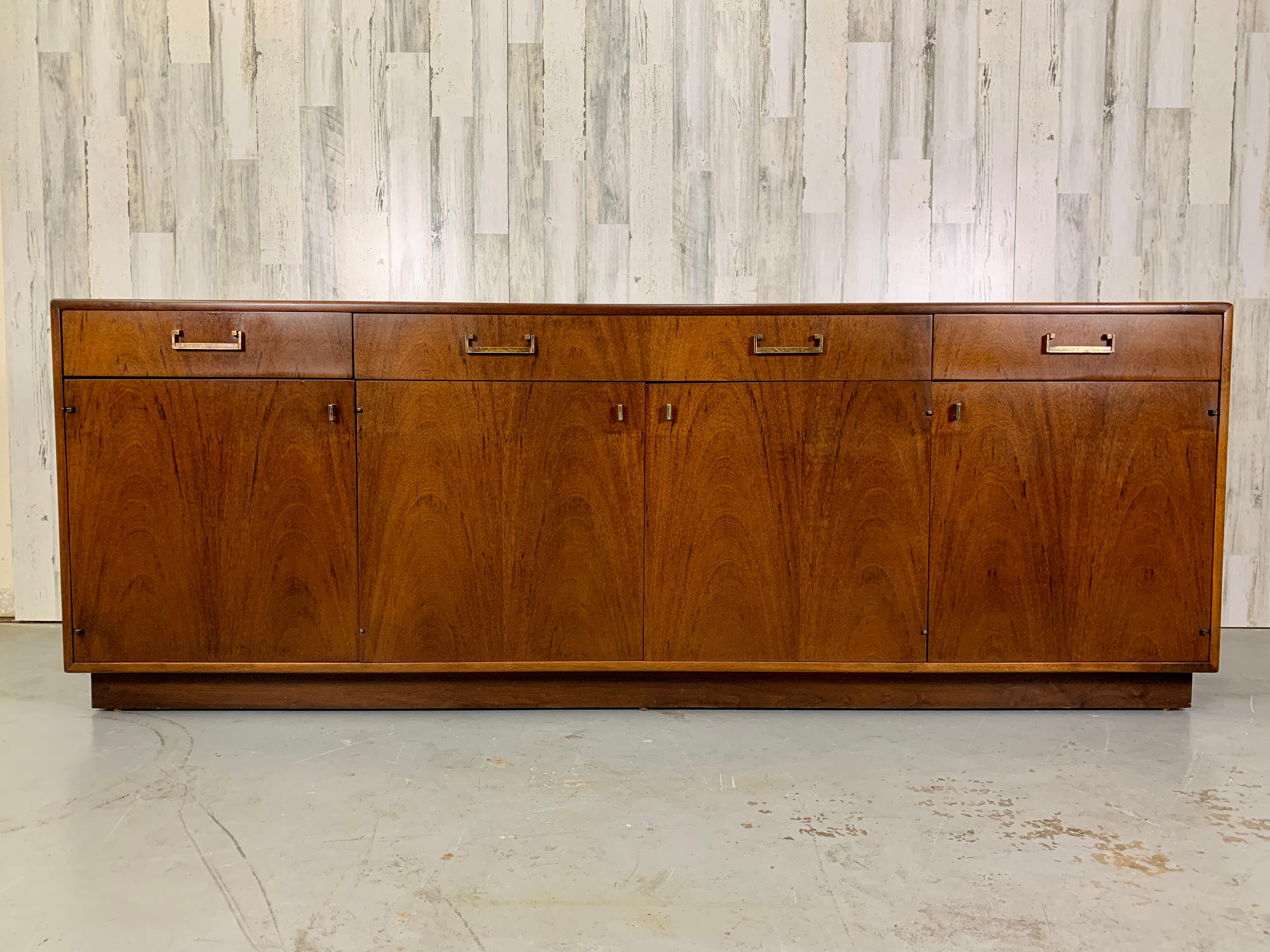 Book match Veneer front three drawer and four door credenza with brass hardware designed by Maurice Villency of New York.