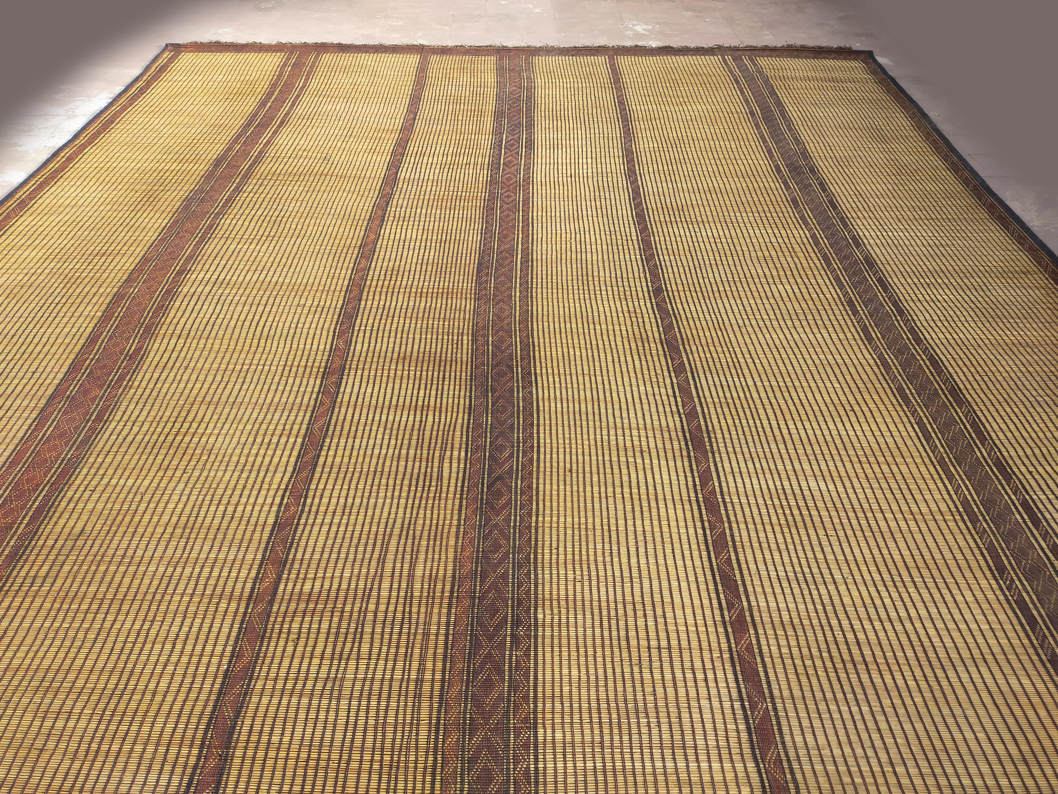 Teppichmatte aus Mauretanien Sahara, aus Palmenholz und Leder mit grafischem Muster, ca. 1950-1960er Jahre.
Abmessungen: 180 cm x 310 cm.