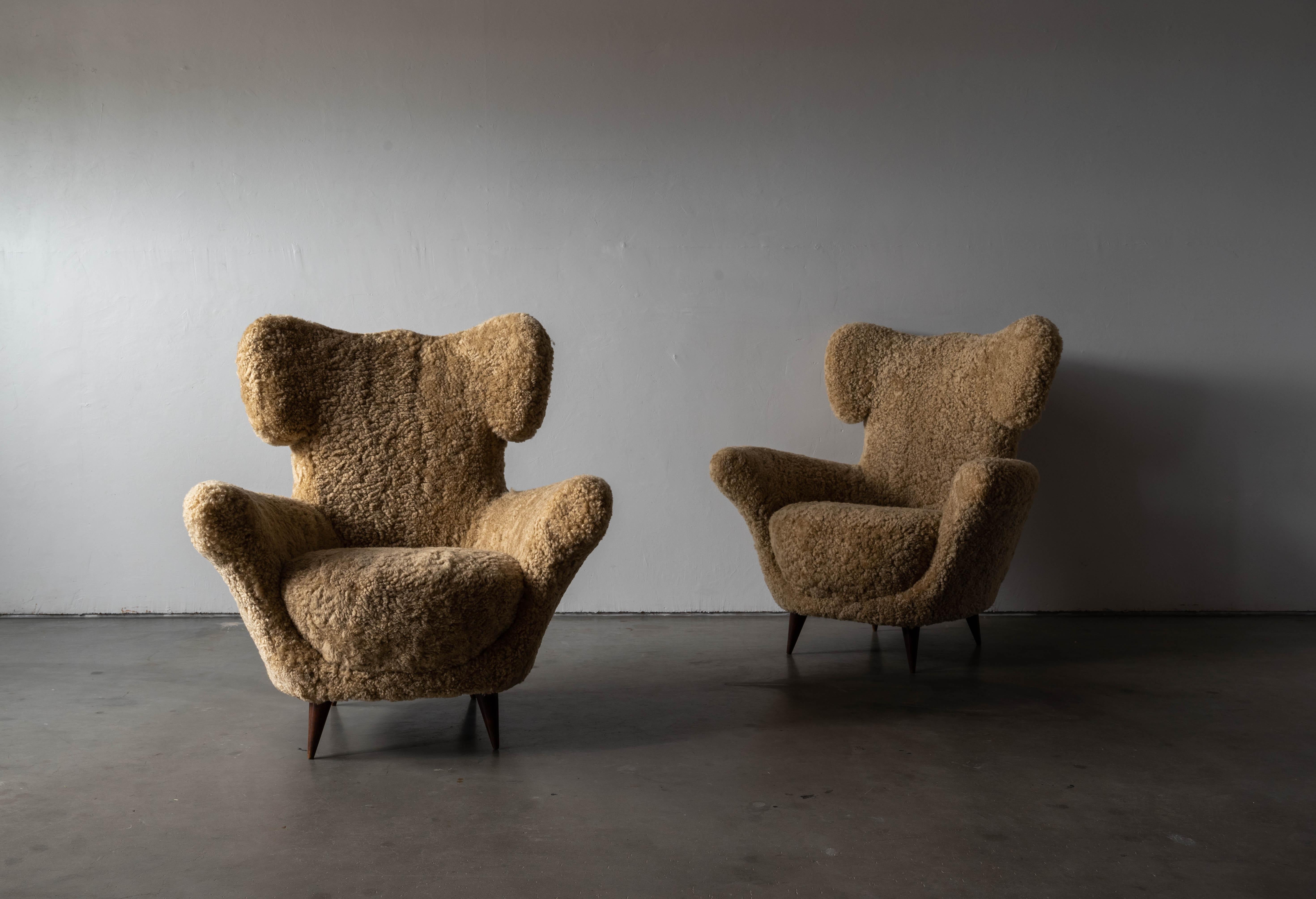 A pair of wood and shearling lounge chairs, design attributed to Maurizio Tempestini, Italy, c. 1950.