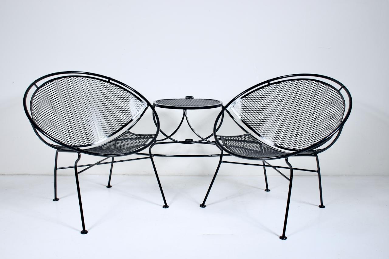 Maurizio Tempestini for John Salterini Pair Radar Chairs & Occasional Table. Patio Set. Lanai Set. Featuring a Wrought Iron and woven wire mesh framework with attached pair of curved, ergonomic Lounge Chairs and adjoining (16D x 22.5H) round Table