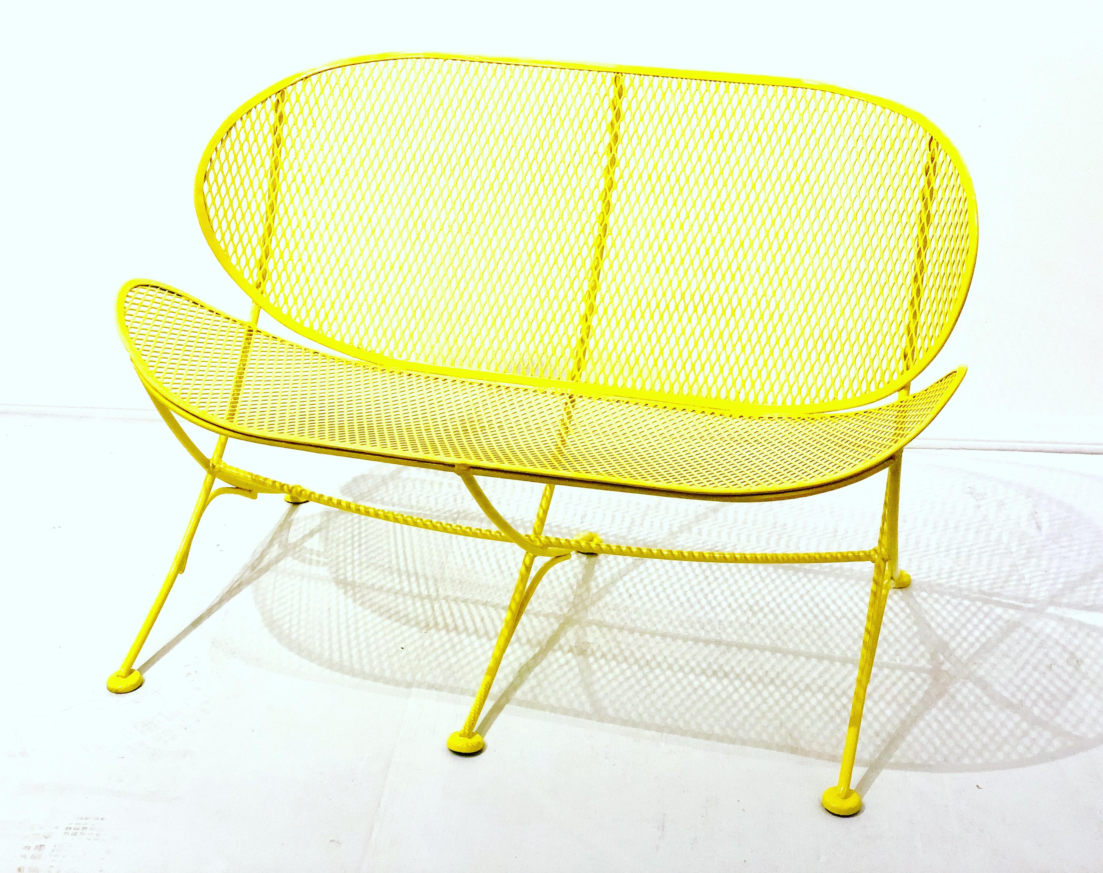 Outdoor clam shell lounge patio loveseat designed by Maurizio Tempestini and manufactured Salterini can be used on the terrace, patio, porch or in the garden. This piece its all-iron and has been repainted in yellow has that perfect 1950s Atomic