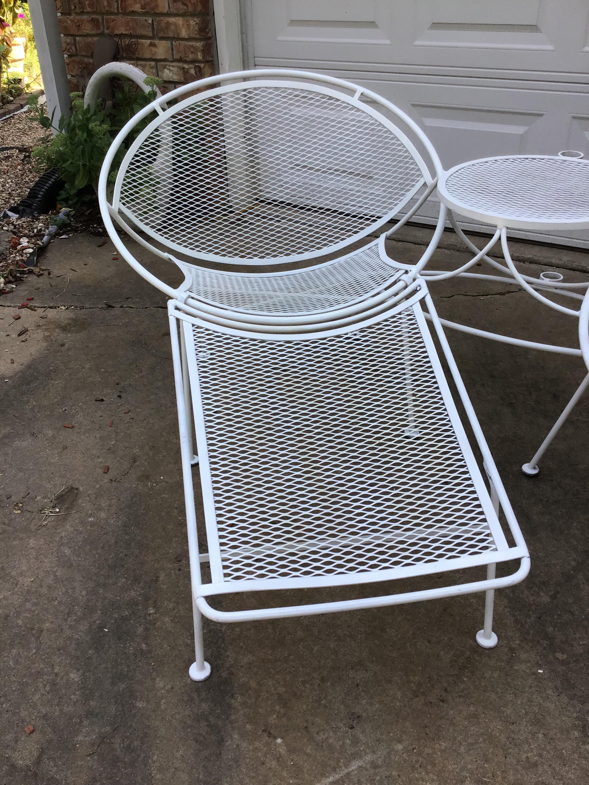 This is a very nice example of a Salterini tete au tete. It consists of two radar lounge chairs linked together in the center with a table. There is a place to hold an umbrella over the set as well. This set comes with a rare attachable ottoman to