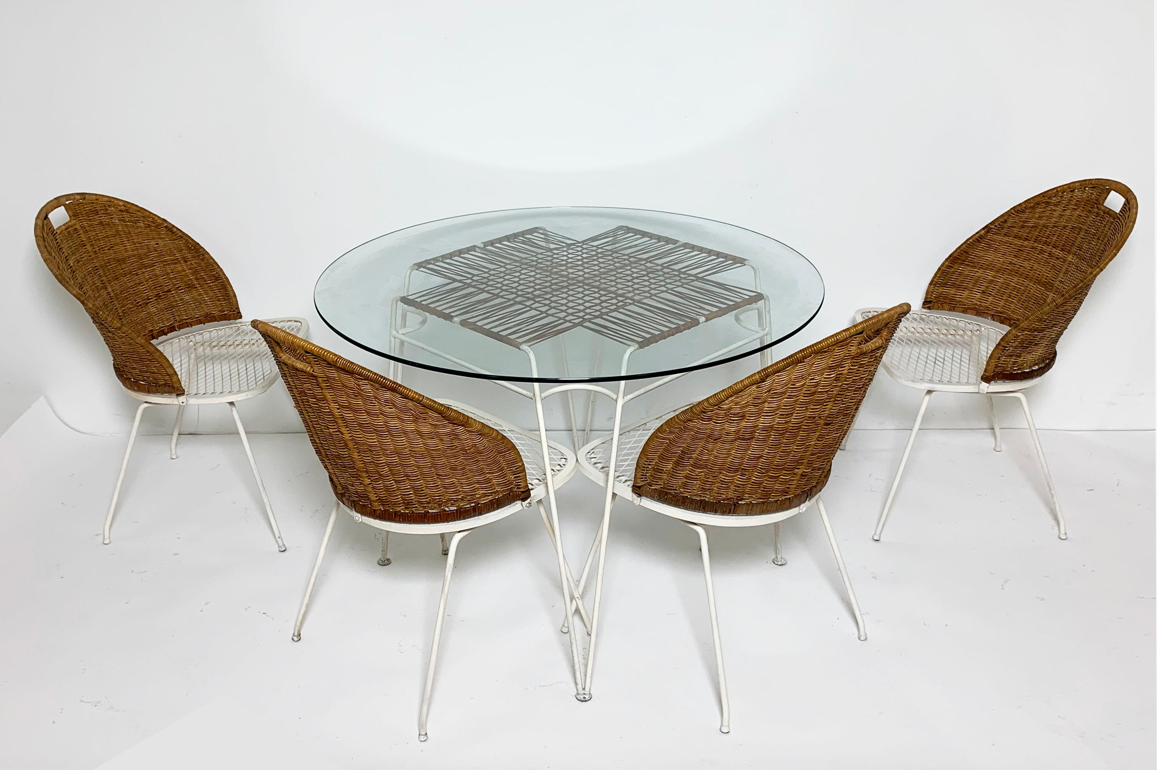 Classic outdoor seating designed by Maurizio Tempestini for John Salterini, ca. 1950s. Features four steel and wicker Neva-Rust chairs and a very rare cafe table featuring a grid of woven cane architecture beneath its glass top.

With glass top,