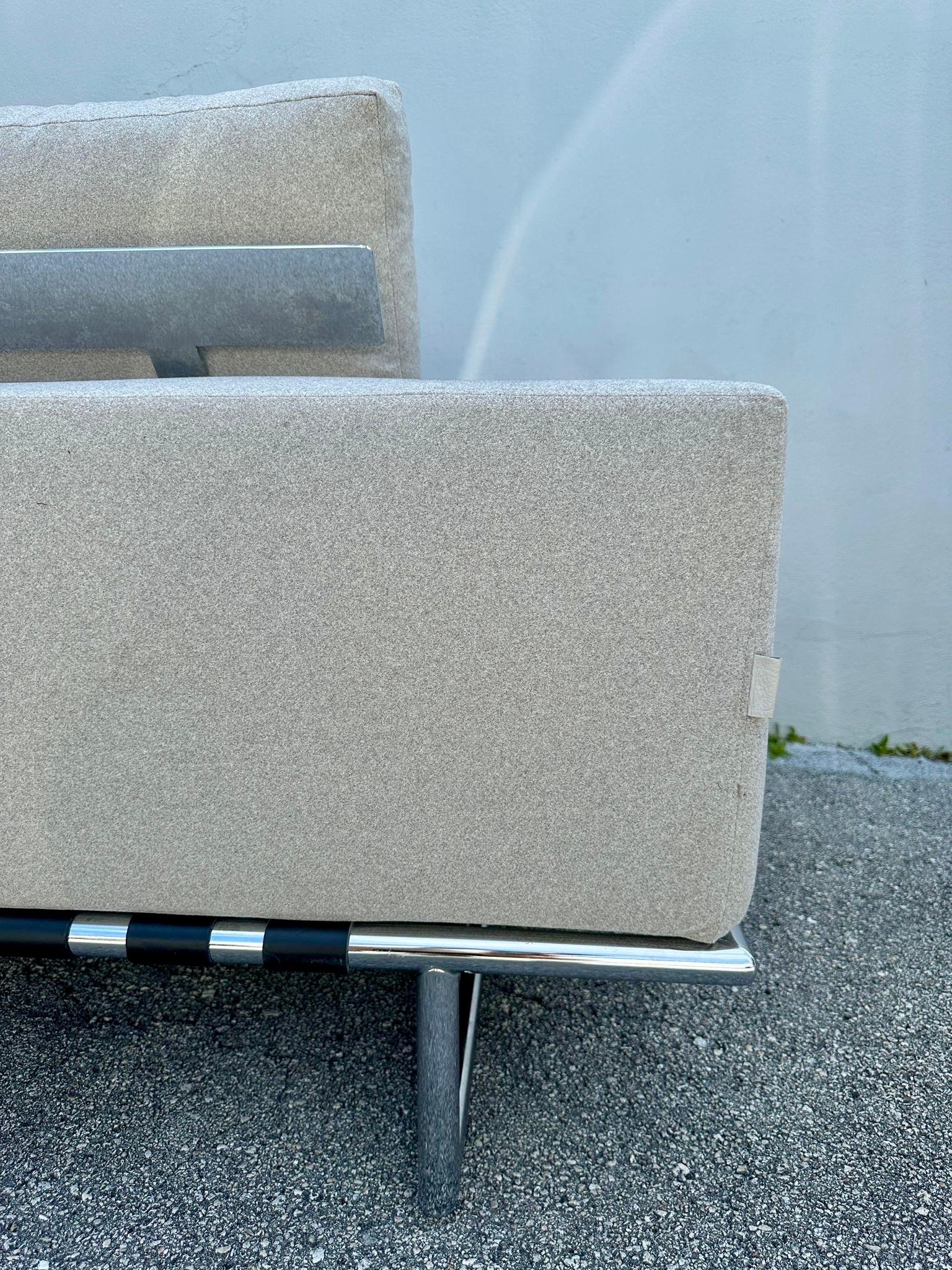 Questo eccezionale divano cromato a due posti è profondo e confortevole, con cinghie originali in tessuto e pelle - etichetta originale.  Le cinghie di cuoio avvolte intorno alla struttura in acciaio della base danno un'impressione di robustezza, in