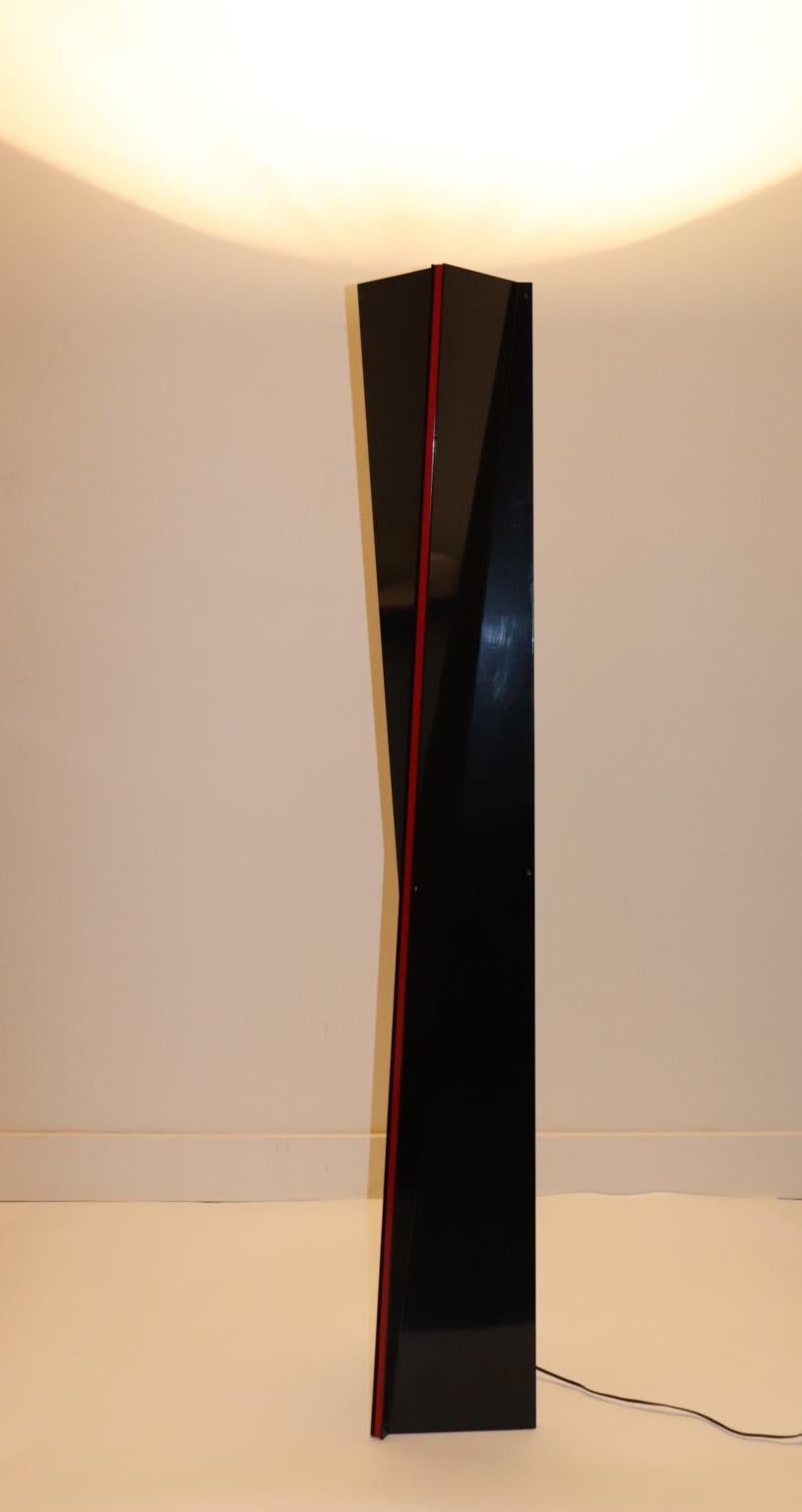 Italian sculptured floor lamp. Black lacquered aluminum with red stripes details.
The 