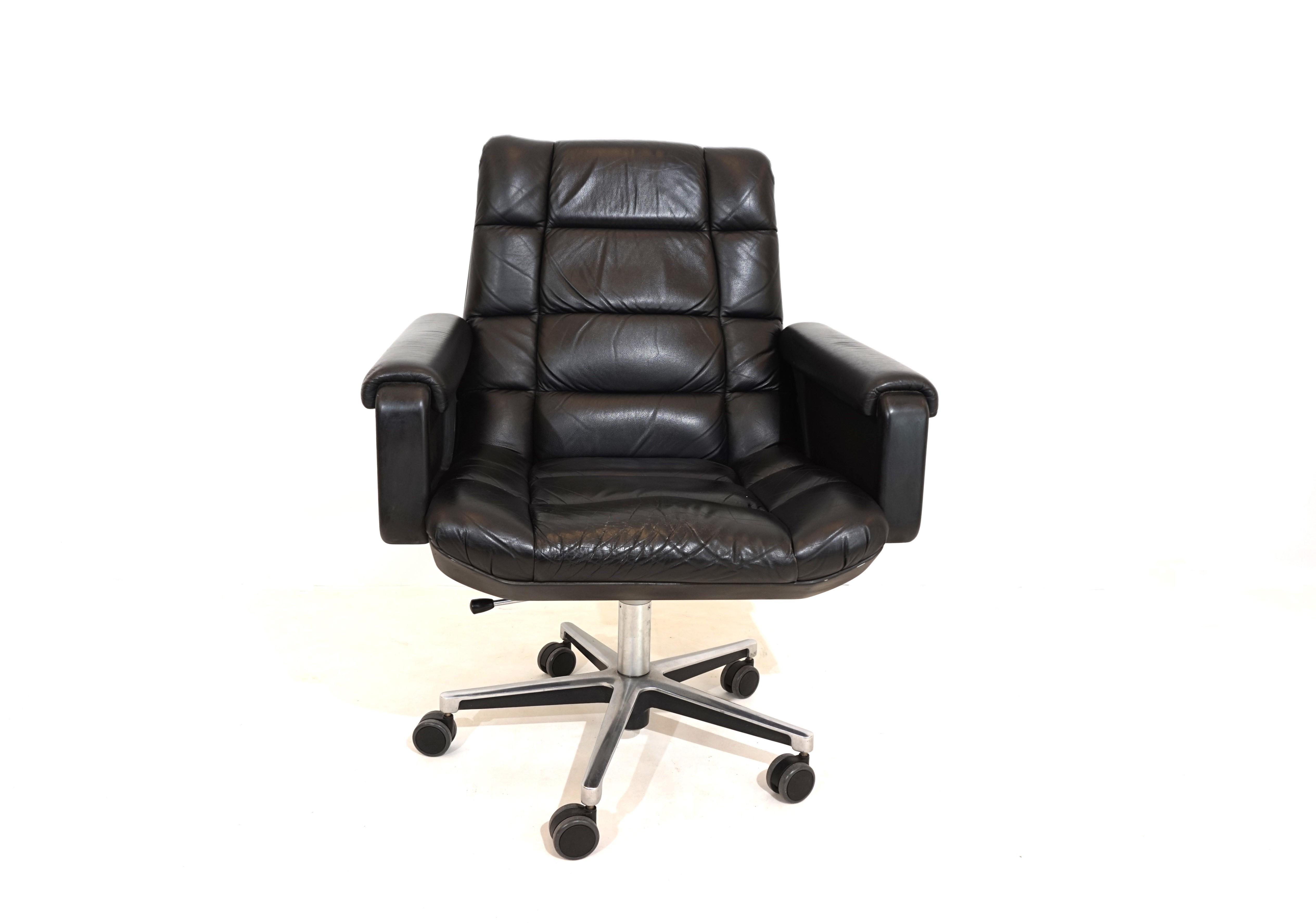A Seat 150 office chair in a black/black color combination. The soft, black, quilted leather is in very good condition with a light patina. The black plastic shell of the backrest showed signs of wear, such as scratches. The plastic shells of the