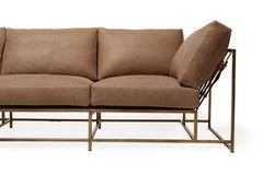 Sofá de piel malva y latón antiguo