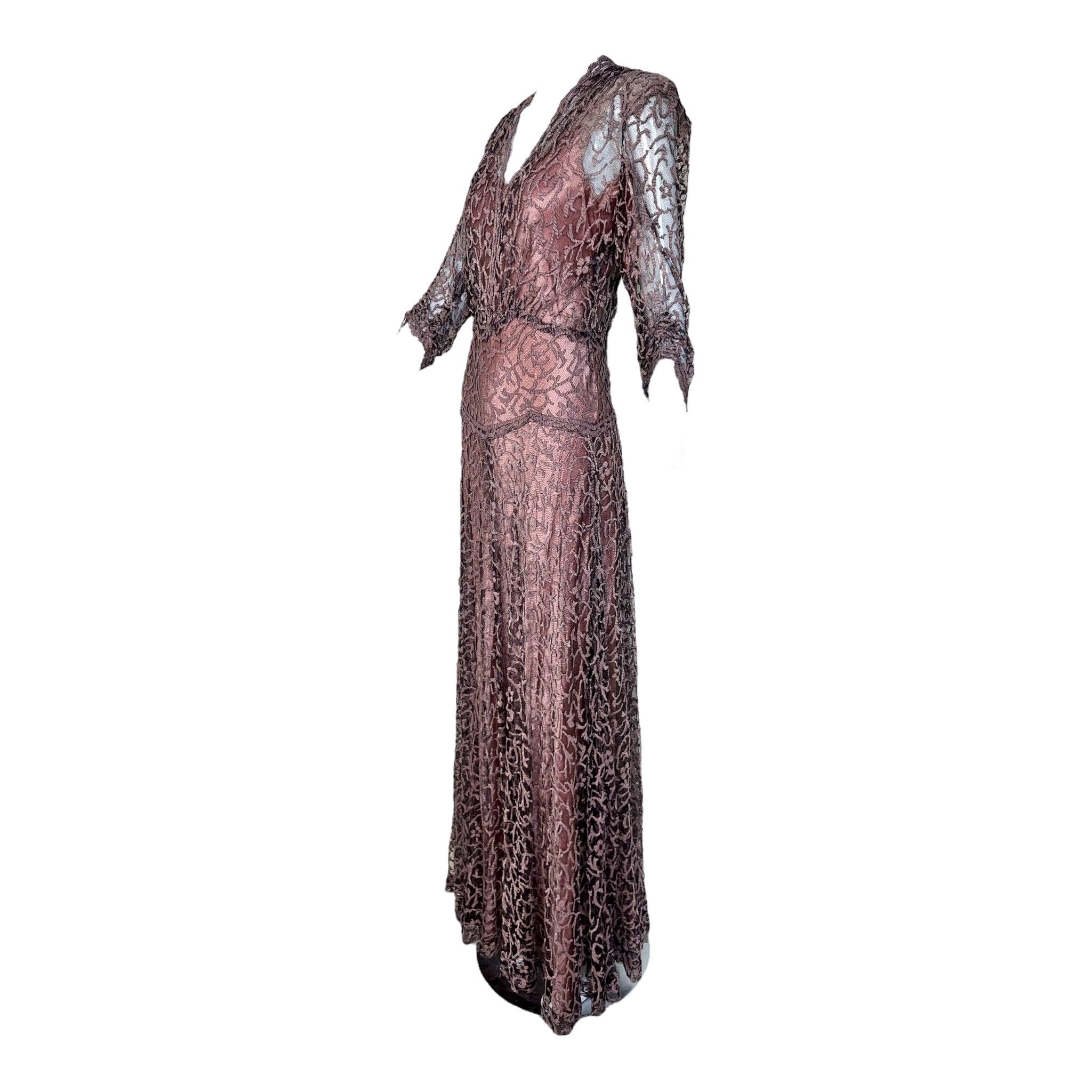 Robe du soir en dentelle des années 1930 Romantique et lunatique Motif floral filigrané en dentelle sur filet noir. Des fils de lamé sont tissés dans le filigrane mauve. L'étui en crêpe rose mauve satiné assorti donne vie à la dentelle. Encolure en