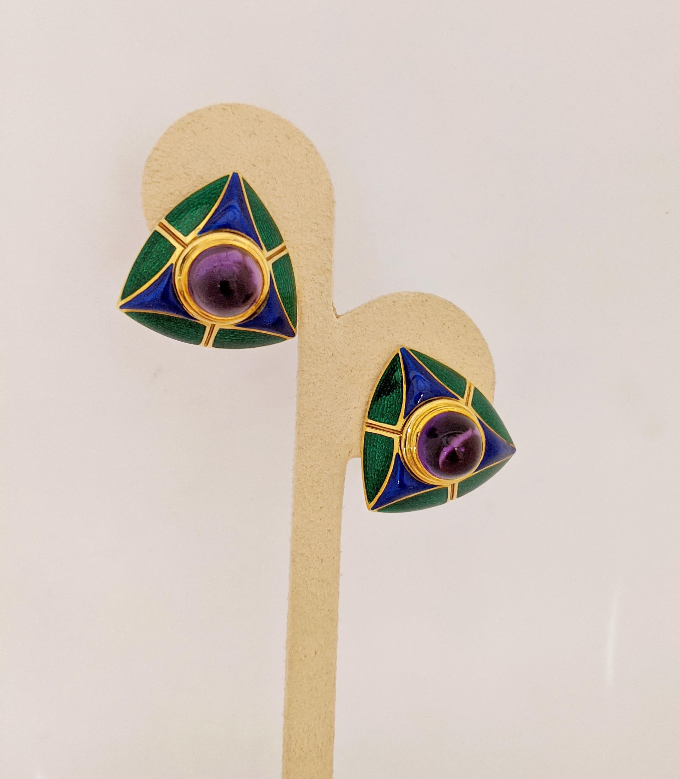 These triangular shaped earrings are 18 karat yellow gold and feature round cabachon Amethyst centers. The earrings have a geometric pattern of blue and green enamel. The green enamel portion has been beautifully guiocheled for added depth. The