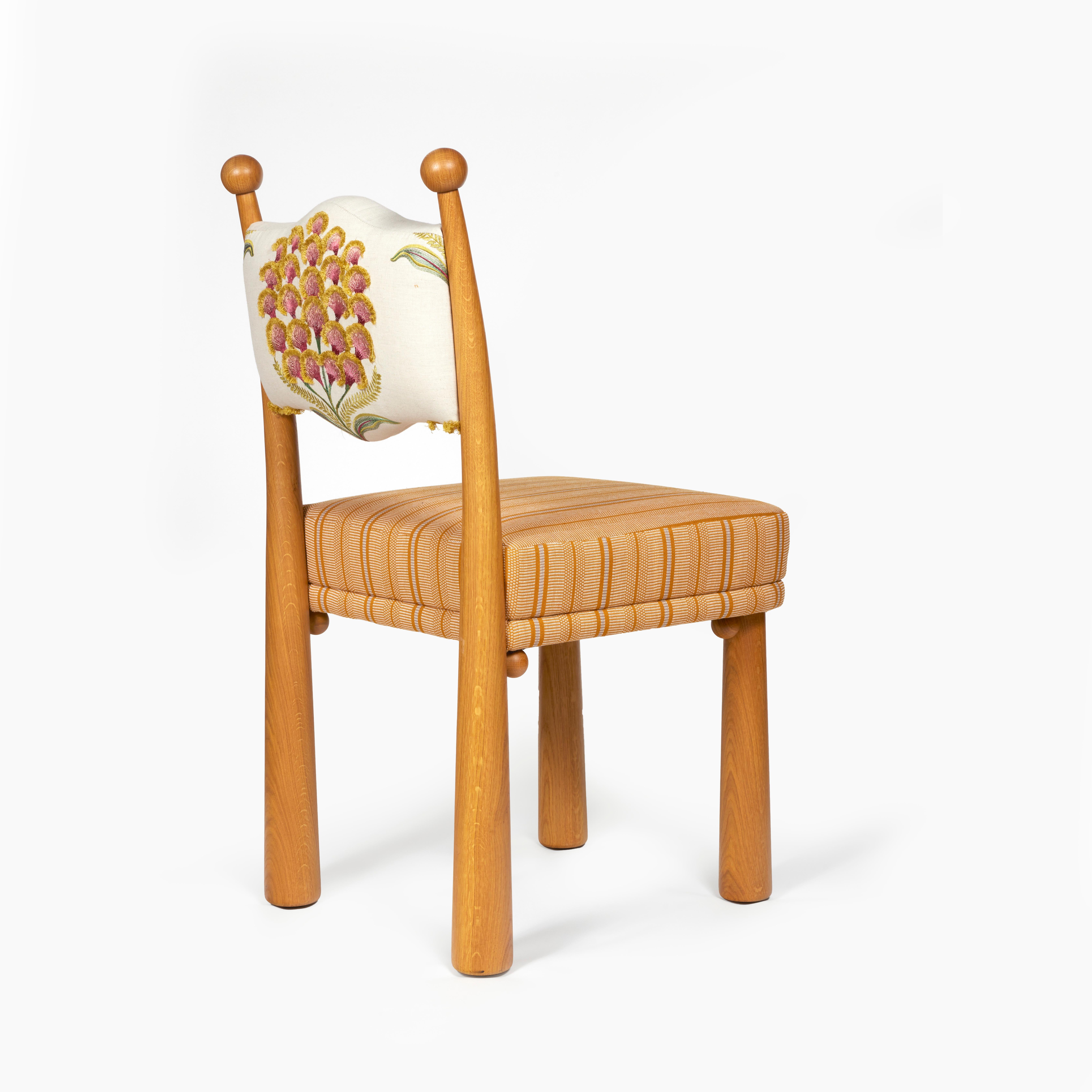 Chaise tapissée d'un tissu naturel brodé de Schumacher.
Menuiserie pour la base et la structure du dossier en chêne doré poncé.
 