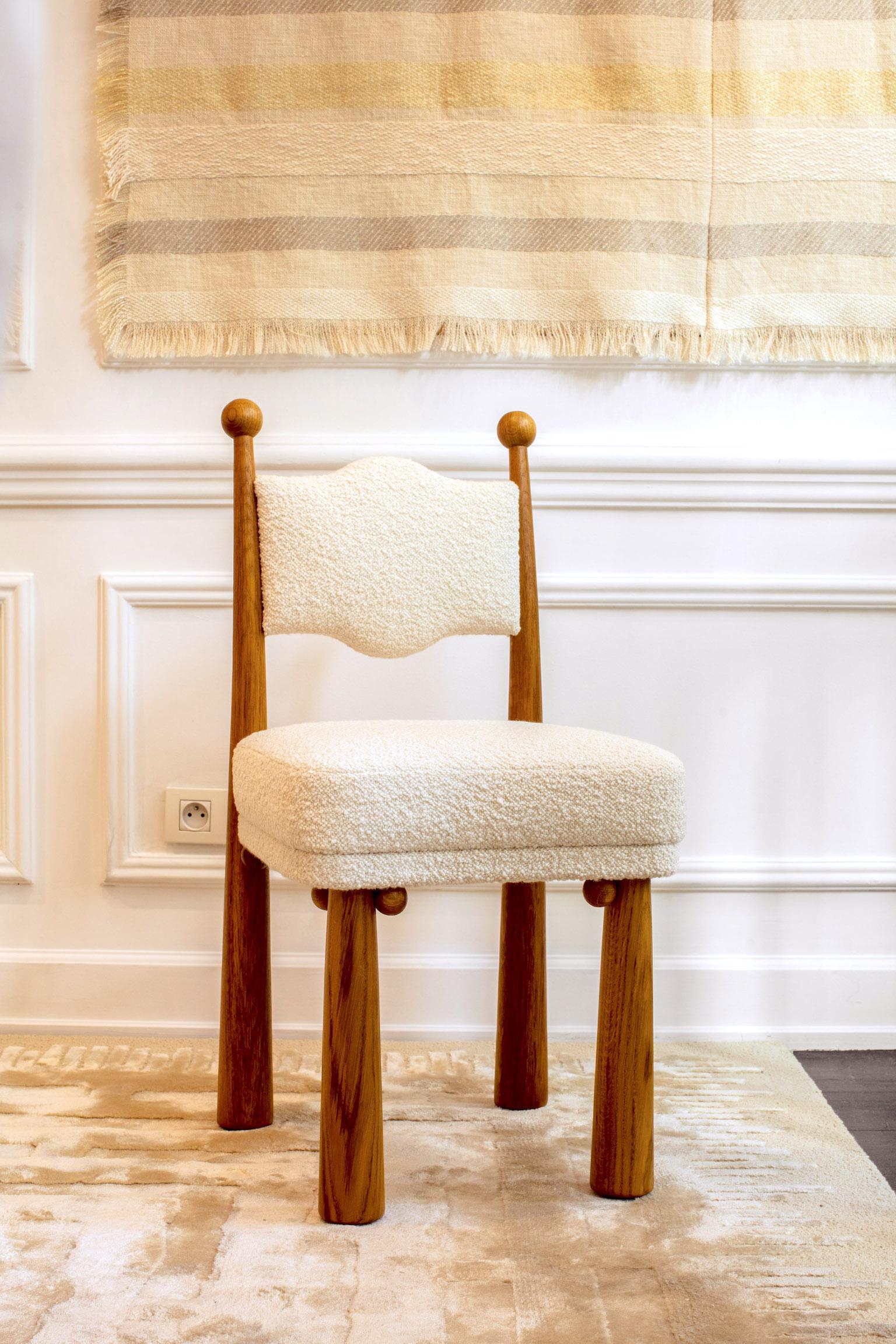 Made in France with hand-turned, flared oak legs. Upholstered backrest and seat in a textured cream bouclette fabric (LG.FB-89).