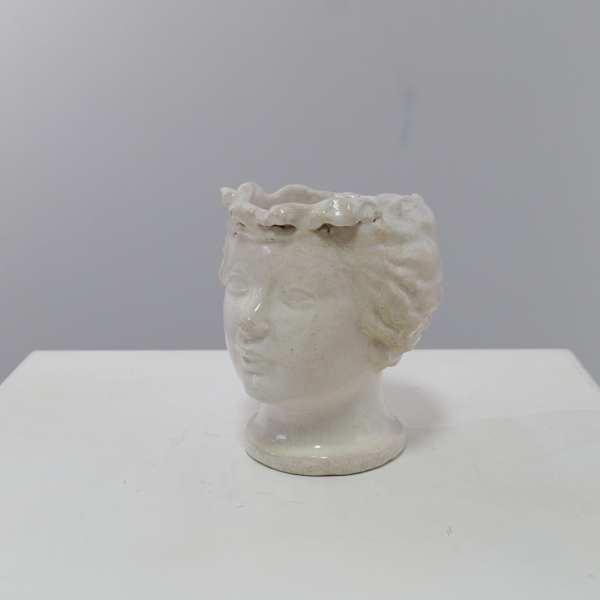 Die weiß glasierte Keramikvase in Form eines Kopfes von Max Barneaud wurde 1947 in Paris geschaffen.
Die gleichzeitige Darstellung eines Kopfes macht das Objekt sehr dekorativ.