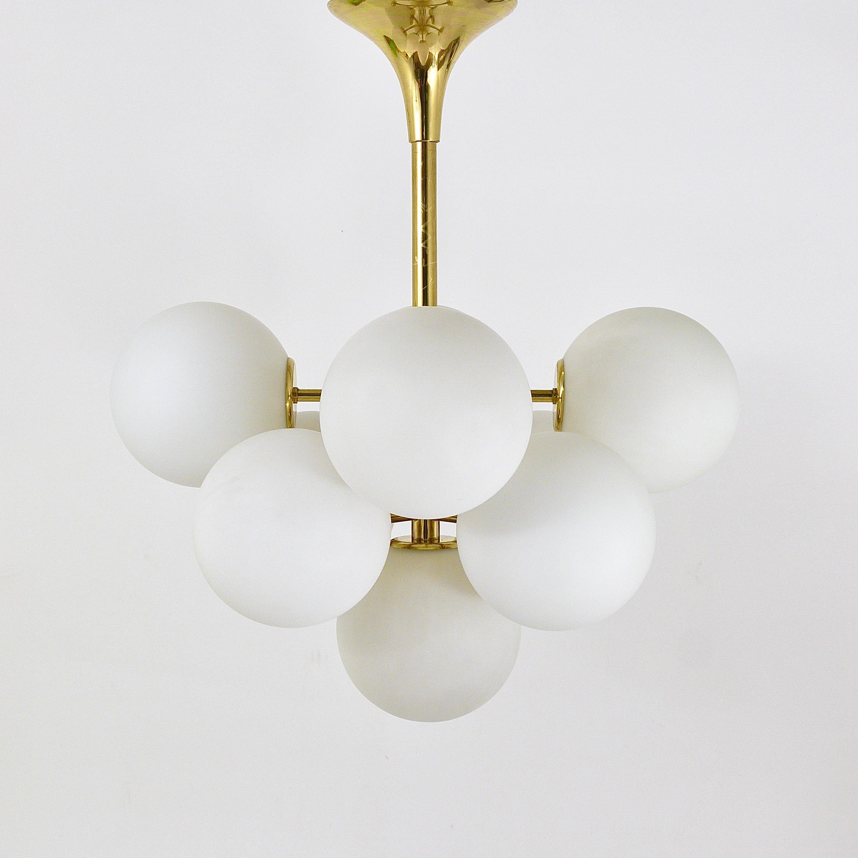 A stylish 1960s Space Age Atomic Sputnik-style chandelier. In the style of E. R. Nele, executed by Temde, Switzerland. Brass hardware with a tulip canopy and nine white frosted hand blown glass globe shades. In good condition with some patina on the