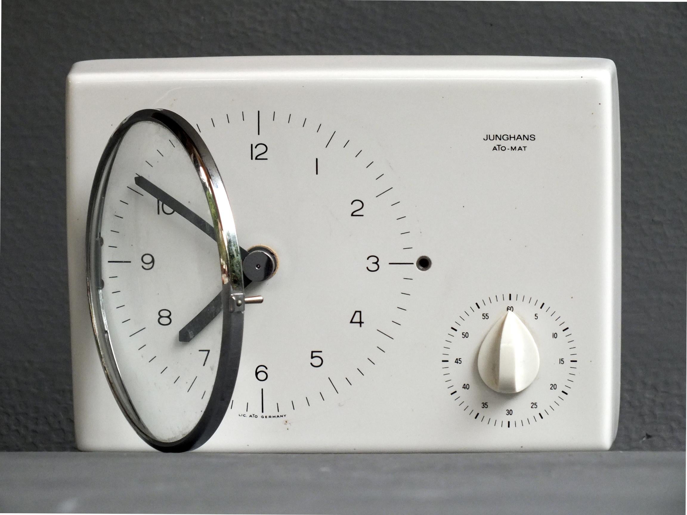 Max Bill Design Jahre '60 für Junghans Wanduhr ato-mat erste Bearbeitung mit elektro/mechanischem Uhrwerk

     die Uhr ist in Keramik Metall und Kunststoff, in gutem Zustand und sehr selten.

     weiße Farbe, Maße 22 cm x 15 x 5 - 8 x 6 x 2