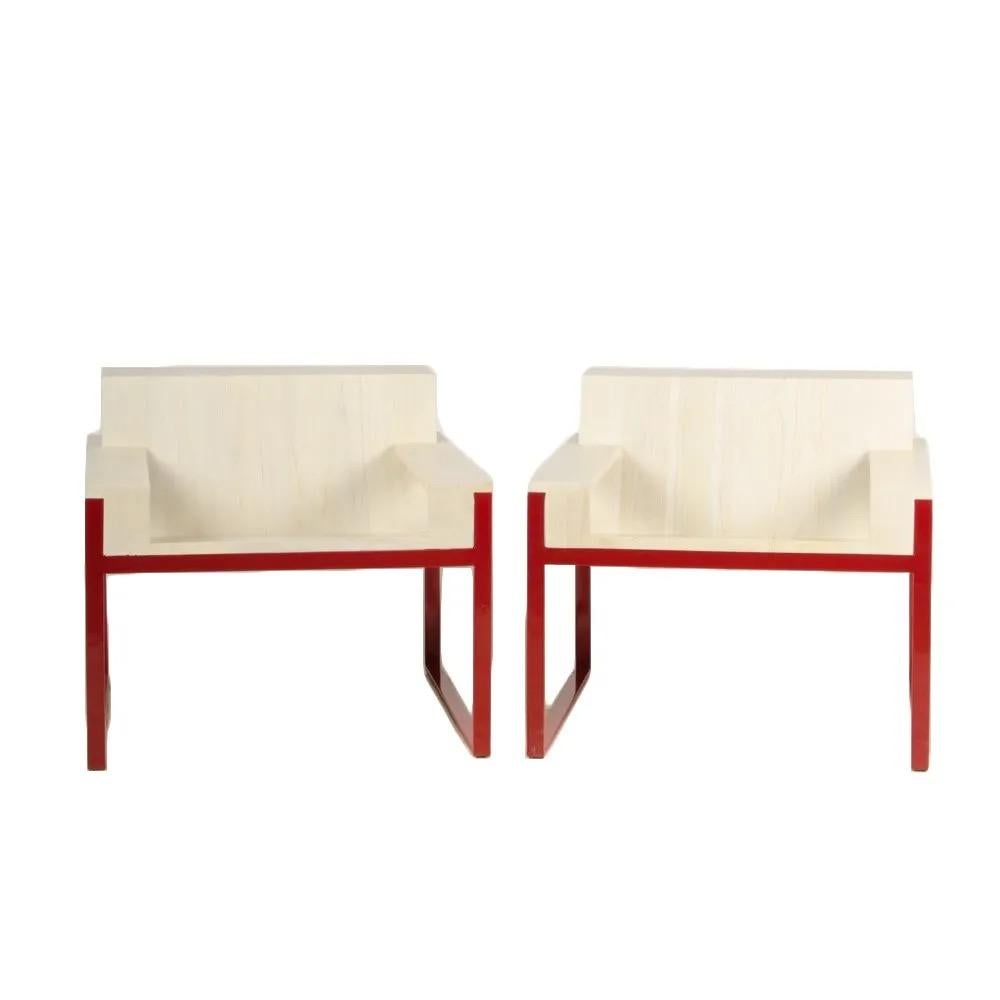 A pair of decorative arm chairs. Solid teak seat with whitewash finish, with soild powder coated steel base in red. 

 Measures: D 27.5 in x W 29.9 in x H 26.4 in

Maximilian Eicke having founded his minimalististic design studio Max ID NY, has