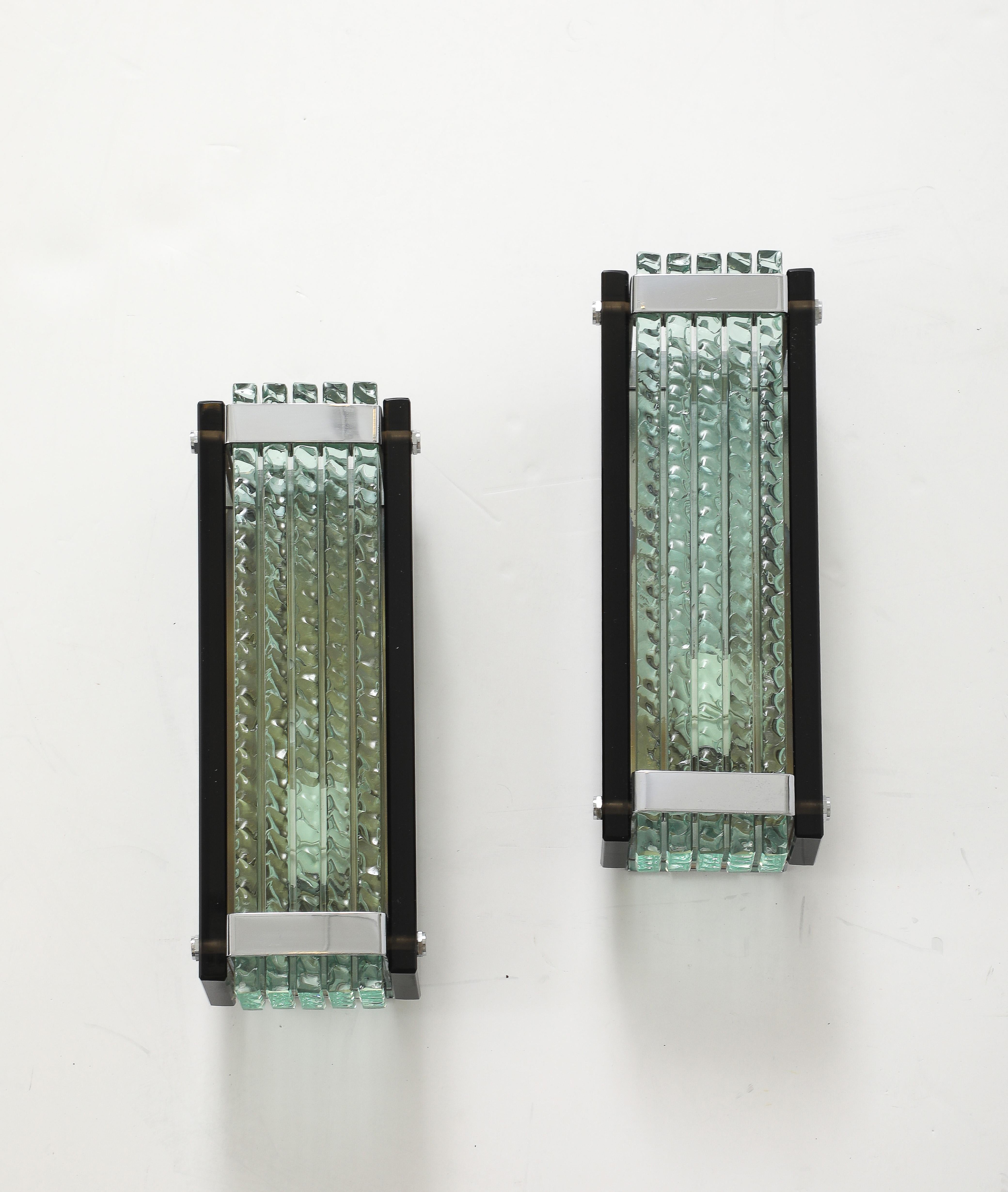 Pair of chiseled murano glass slabs stacked horizontally with smoked glass side panels. Panels are secured by chromed metal bands at top and bottom and side pins. Rewired for use in the USA.
