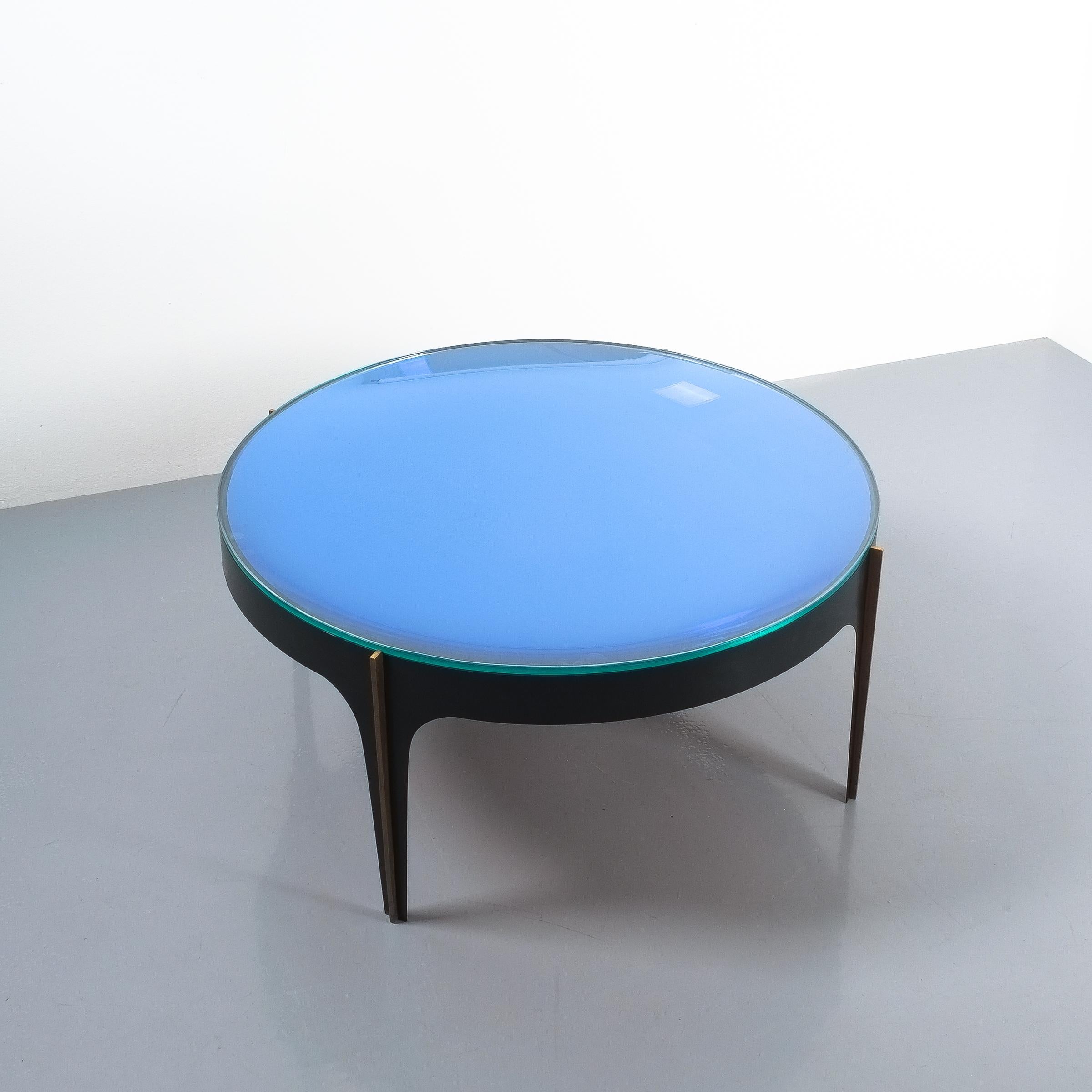 Max Ingrand Fontana Arte coffee table mod. 1774, Italy, circa 1958. Rare original masterpiece by Max Ingrand in very good condition. The base is from curved blackened iron with solid brass pillars attached to the legs; thick glass top on a blue