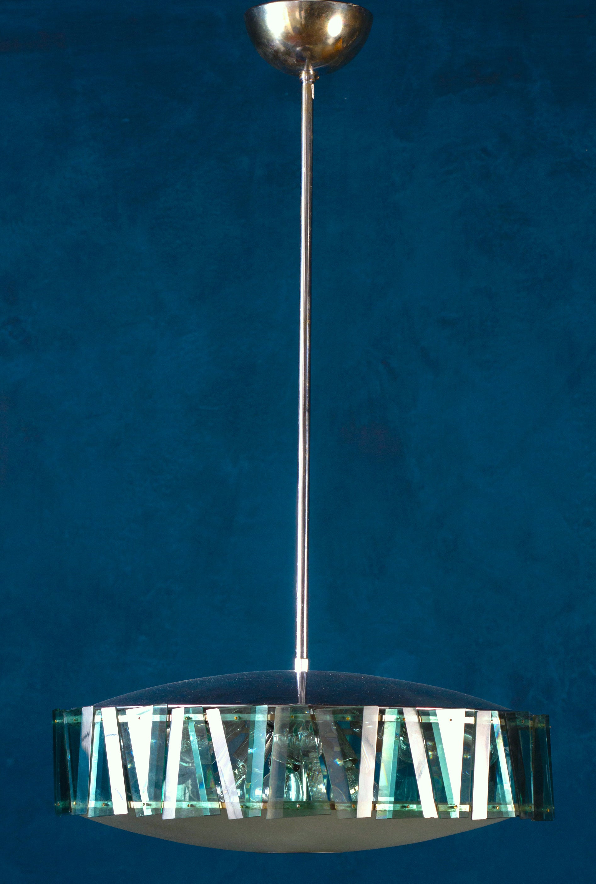 Eleganter minimalistischer Kronleuchter von Max Ingrand für Fontana Arte mit einer Schale aus Milchglas, die von einem wunderschönen grünen, geschliffenen Glasschirm umgeben ist, der von polierten, verchromten Beschlägen getragen wird.
Die Brille