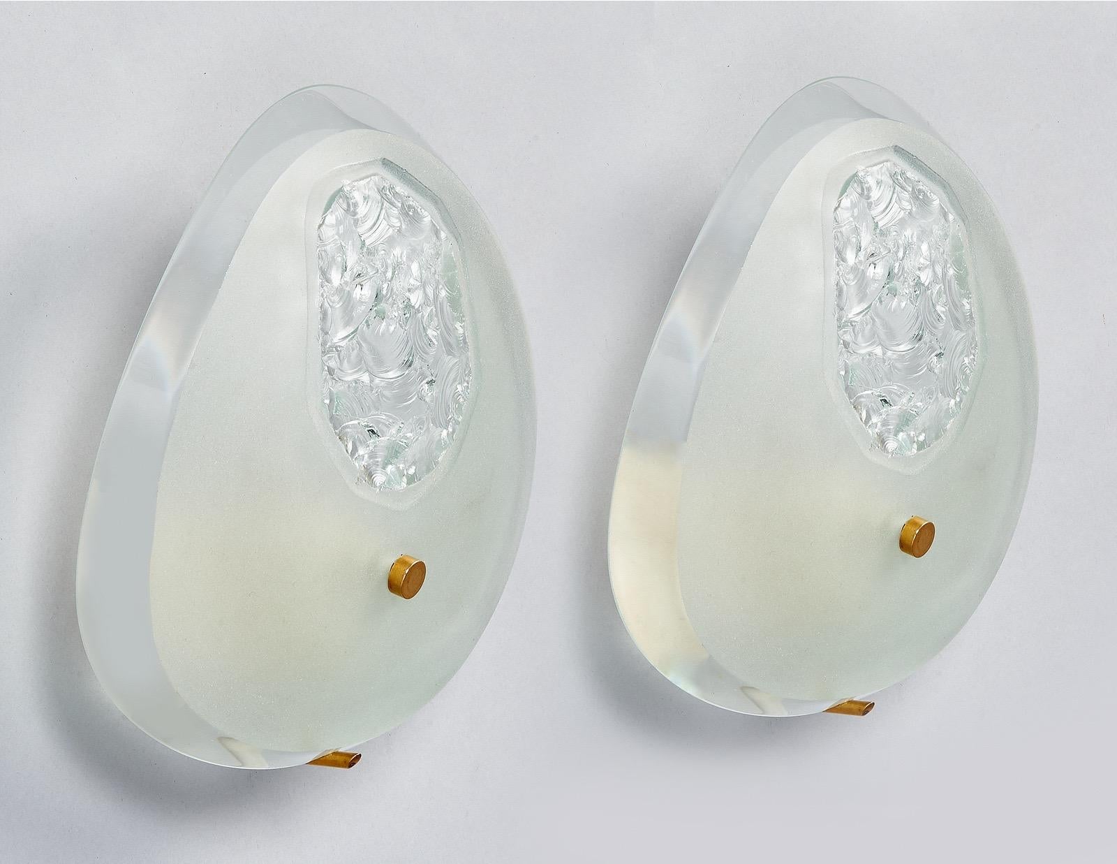 Max Ingrand (1908 - 1969)

A rare and exceptional pair of deep-beveled oval sconces in contrasting polished and frosted glass, by Max Ingrand for Fontana Arte. The sensuous tear-drop shape, in a beautiful and unusually thick glass, is finished with