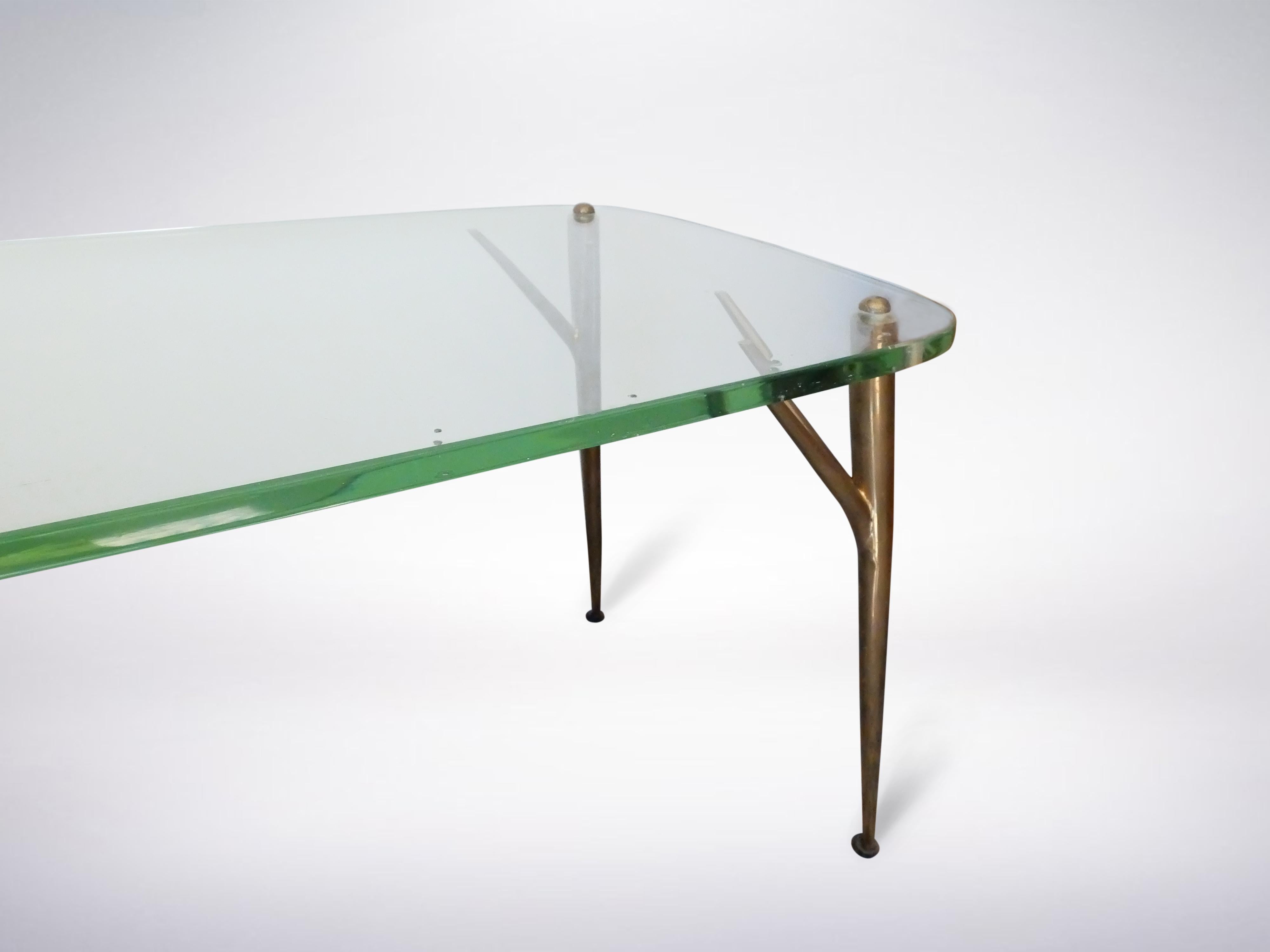 Mesa de centro sobre cuatro patas bifurcadas de latón que sostienen el tablero de cristal ligeramente redondeado. La mesa fue diseñada en 1956 por Max Ingrand para Fontana Arte.



 