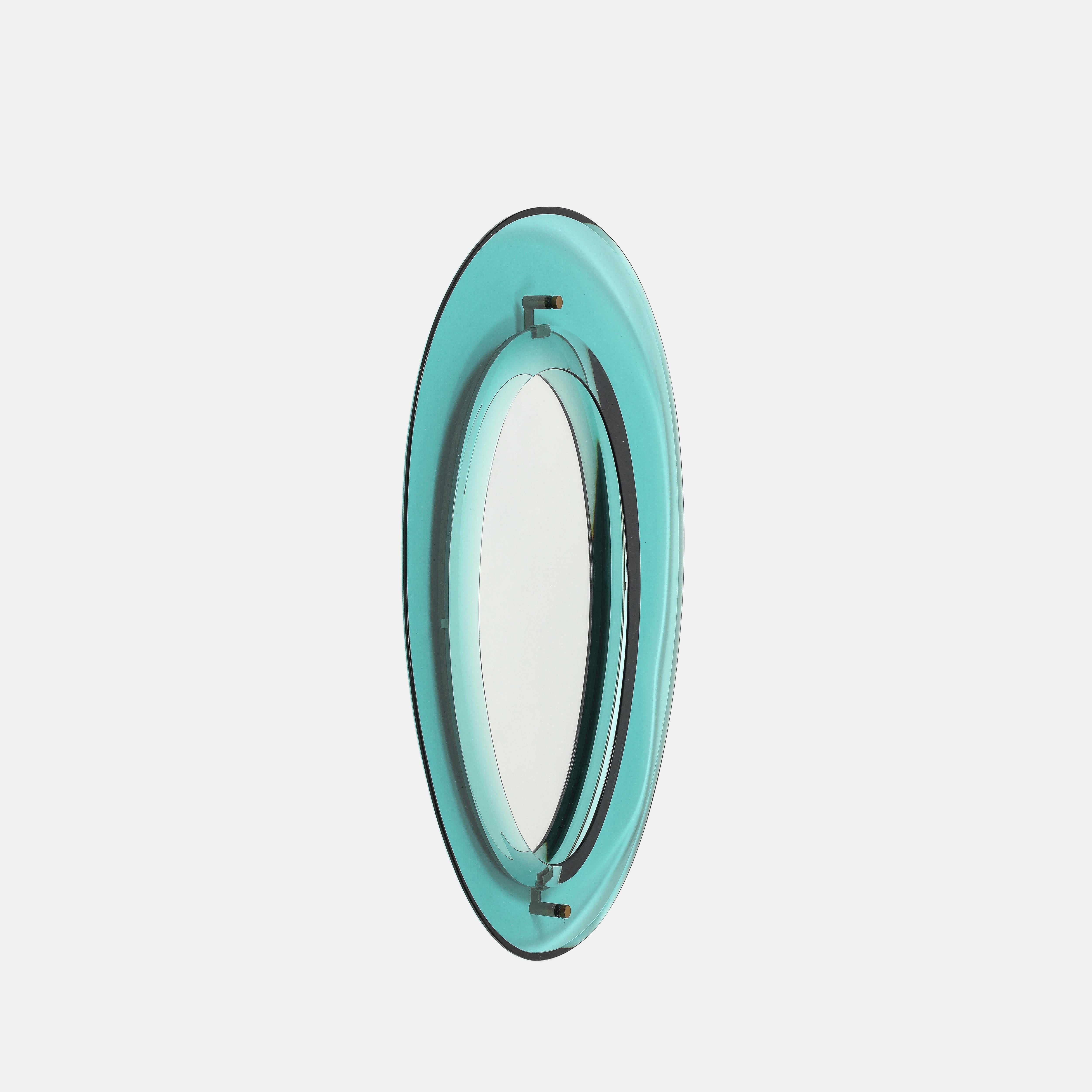 Max Ingrand pour Fontana Arte exquis miroir en verre taillé en forme de bouclier modèle 2046 composé d'un épais cadre en verre coloré bleu vert avec des bords biseautés encadrant le verre miroir original avec des montures en laiton sur un support en