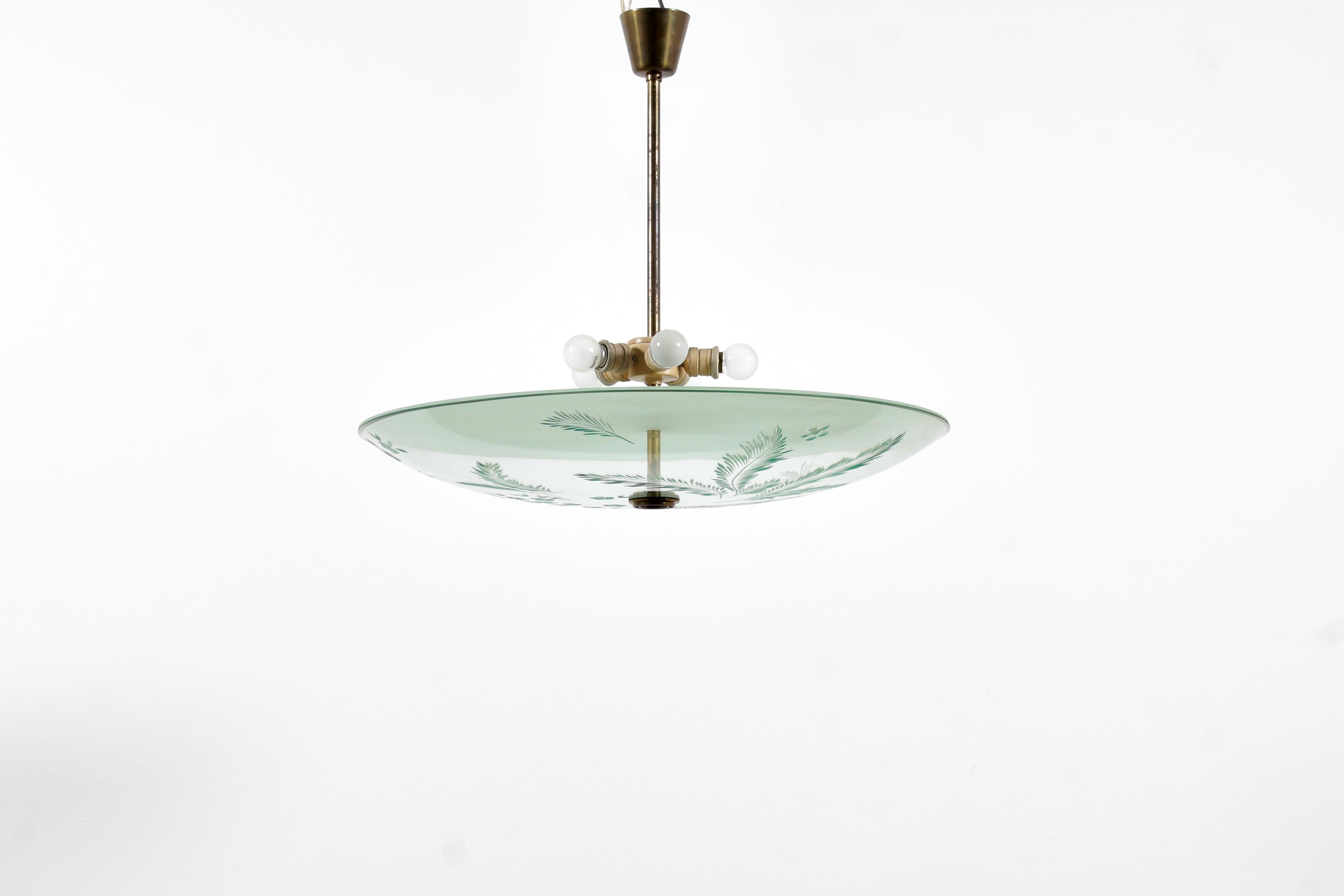 Rare and valuable suspension lamp attributed to Pietro Chiesa for Fontana Arte in the 1940s. Split pin, rod and supports in golden brass, with ground concave disc diffuser, in light green satin glass decorated with engraved floral motifs.