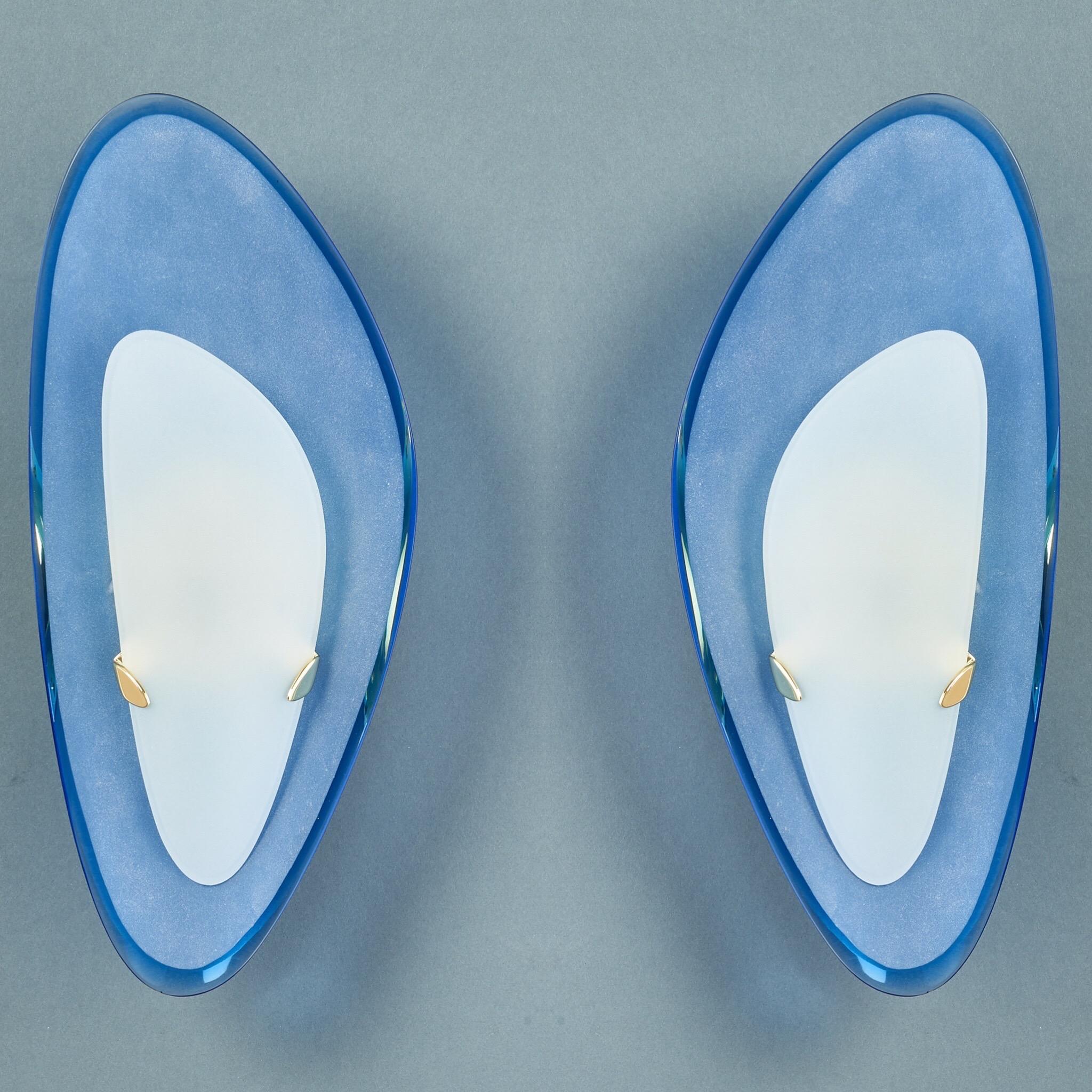 Max Ingrand (1908-1969) for Fontana Arte

A rare and exceptional pair of asymmetric sconces by Max Ingrand for Fontana Arte. With curved and beveled frosted glass shields, mounted by angular brass brackets against notable curved blue beveled