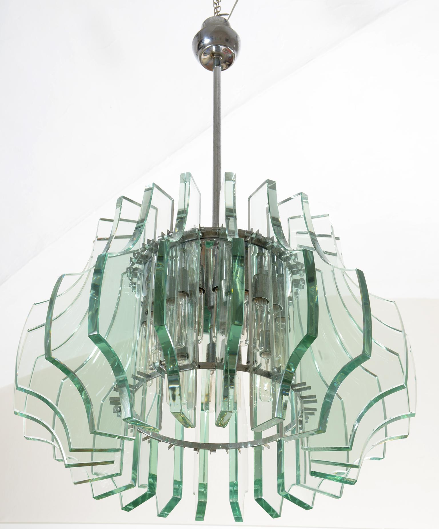 Eighteen bulbs and eighteen shaped and ground beveled crystal elements, nickel-plated brass structure.
Mod. 2411 Fontana Arte Milano design Max Ingrand, circa 1960.
  