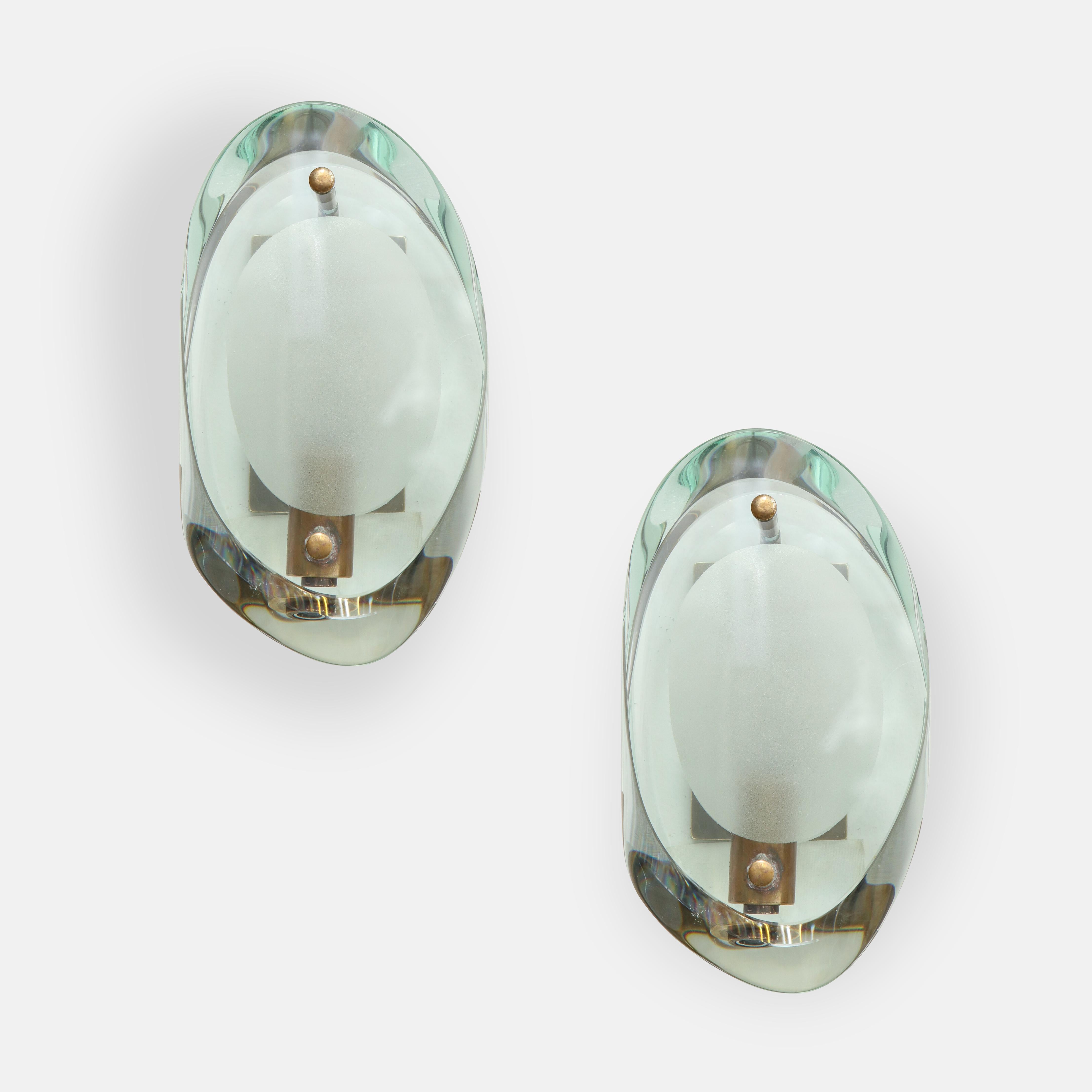 Max Ingrand for Fontana Arte model 2093 pair of sconces consisting of double lens cut panels of thick profiled polished glass with etched glass centers on brass mount and matching custom backplate, Italy, circa 1961.
Recently rewired to U.S.