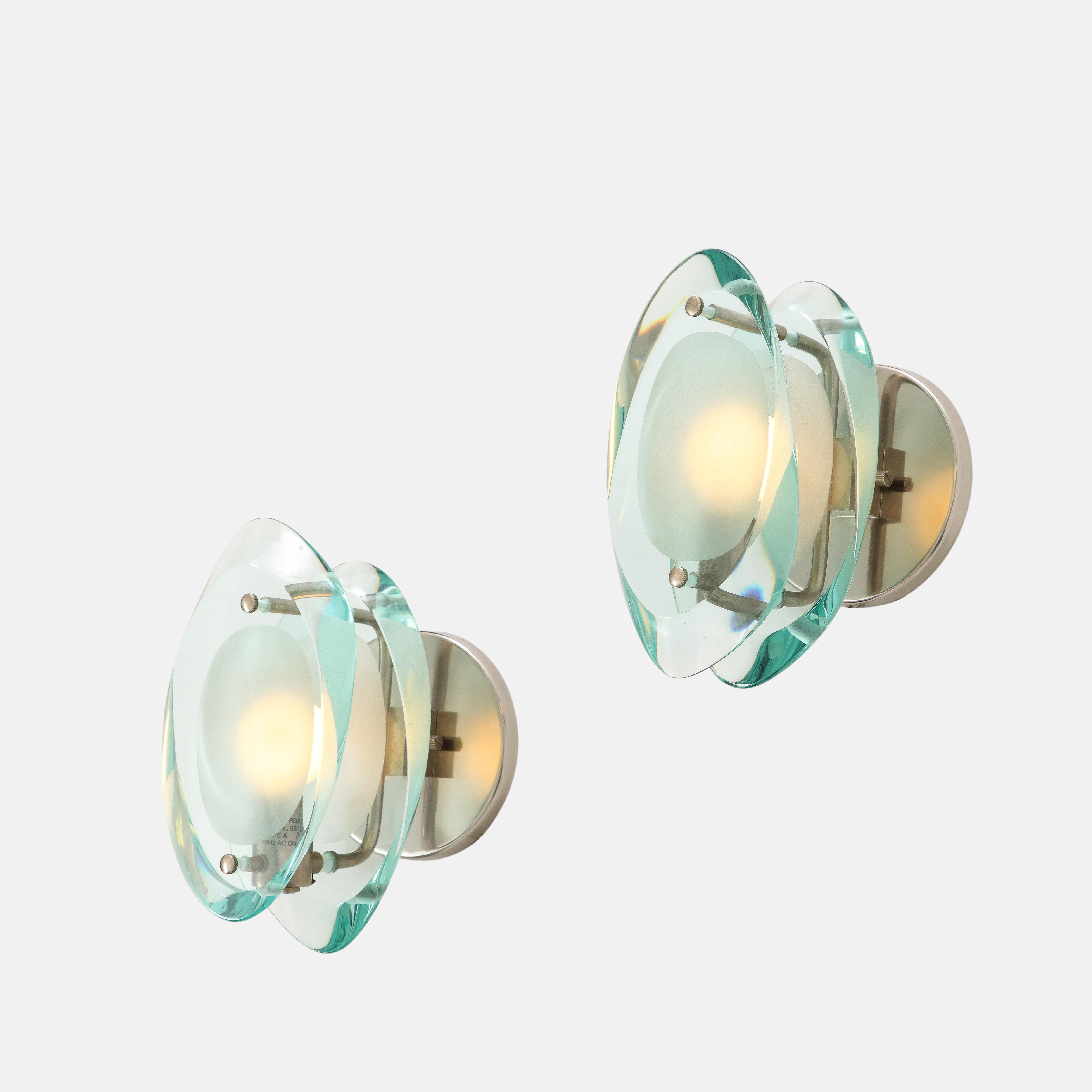 Max Ingrand for Fontana Arte pair of sconces model 2093 with double lens cut panels of thick profiled polished glass with acid-etched glass centers suspended by nickel-plated brass mounts. Rewired to U.S. standards including UL listing and custom